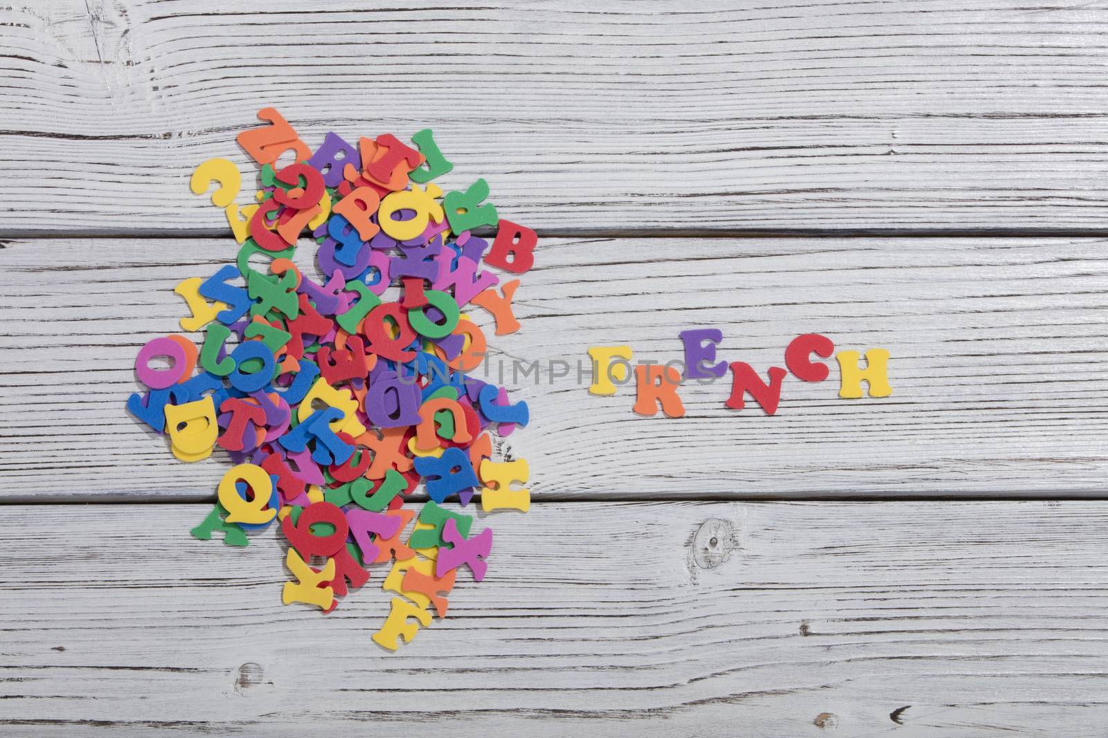 the colorful words french made with colorful letters over white wooden board by senkaya