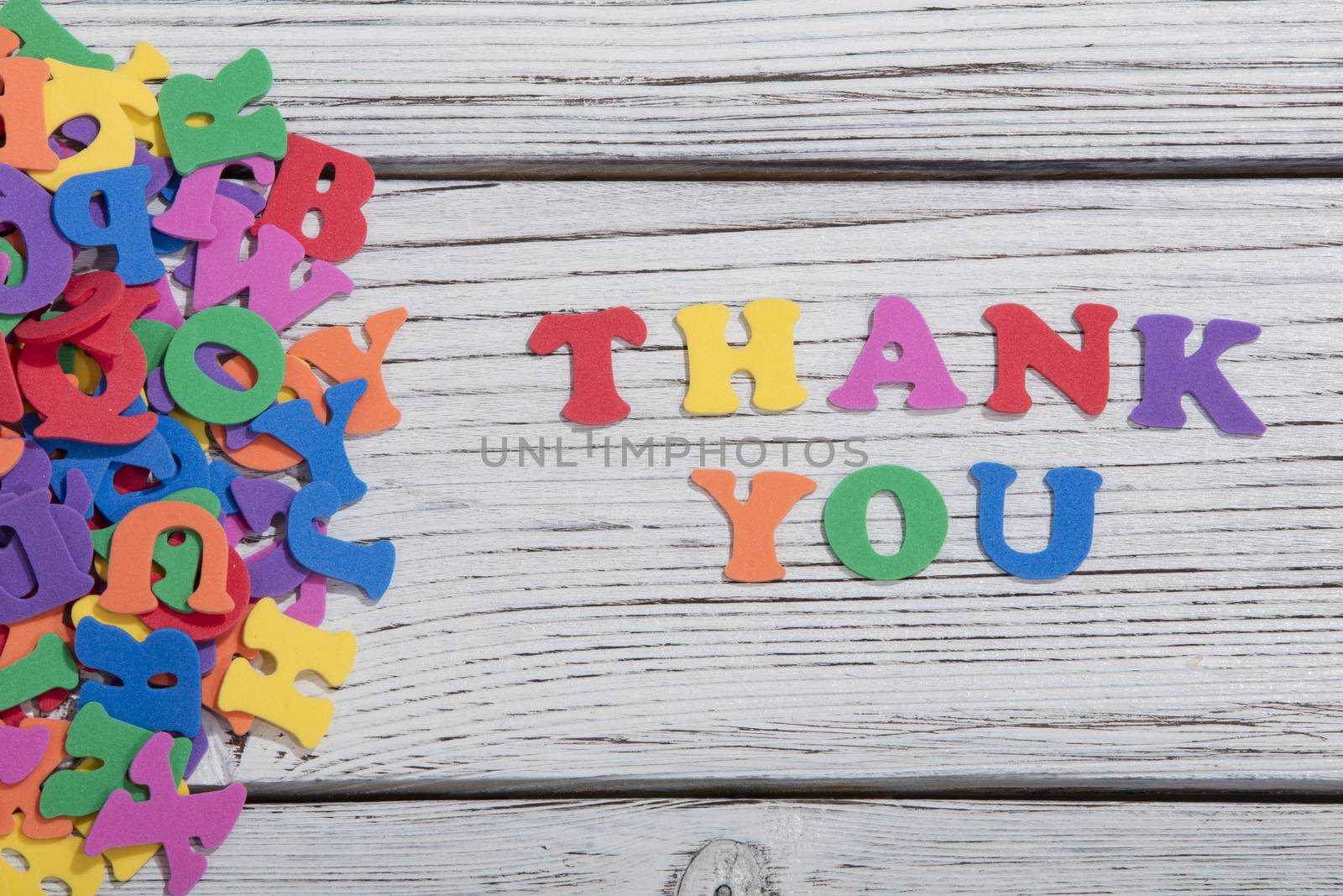 the colorful words thank you made with colorful letters over white wooden board by senkaya