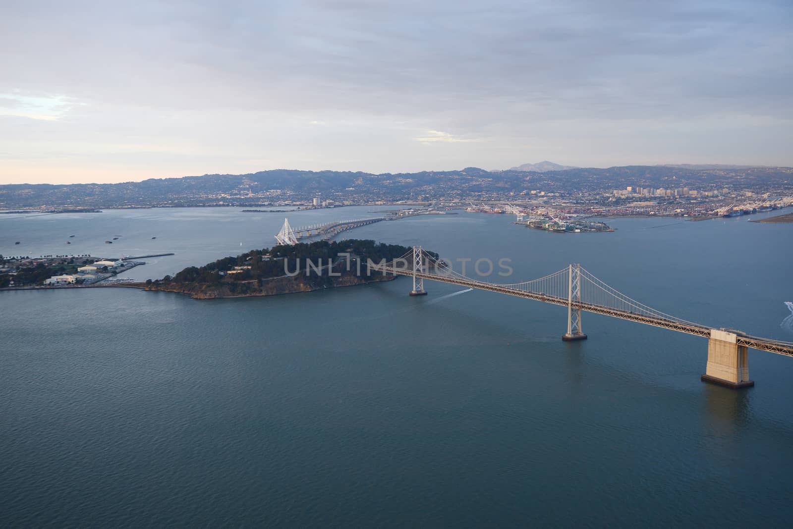 an aerial view of bay bridge near san francisco downtown during sunset, taken from a helicopter 