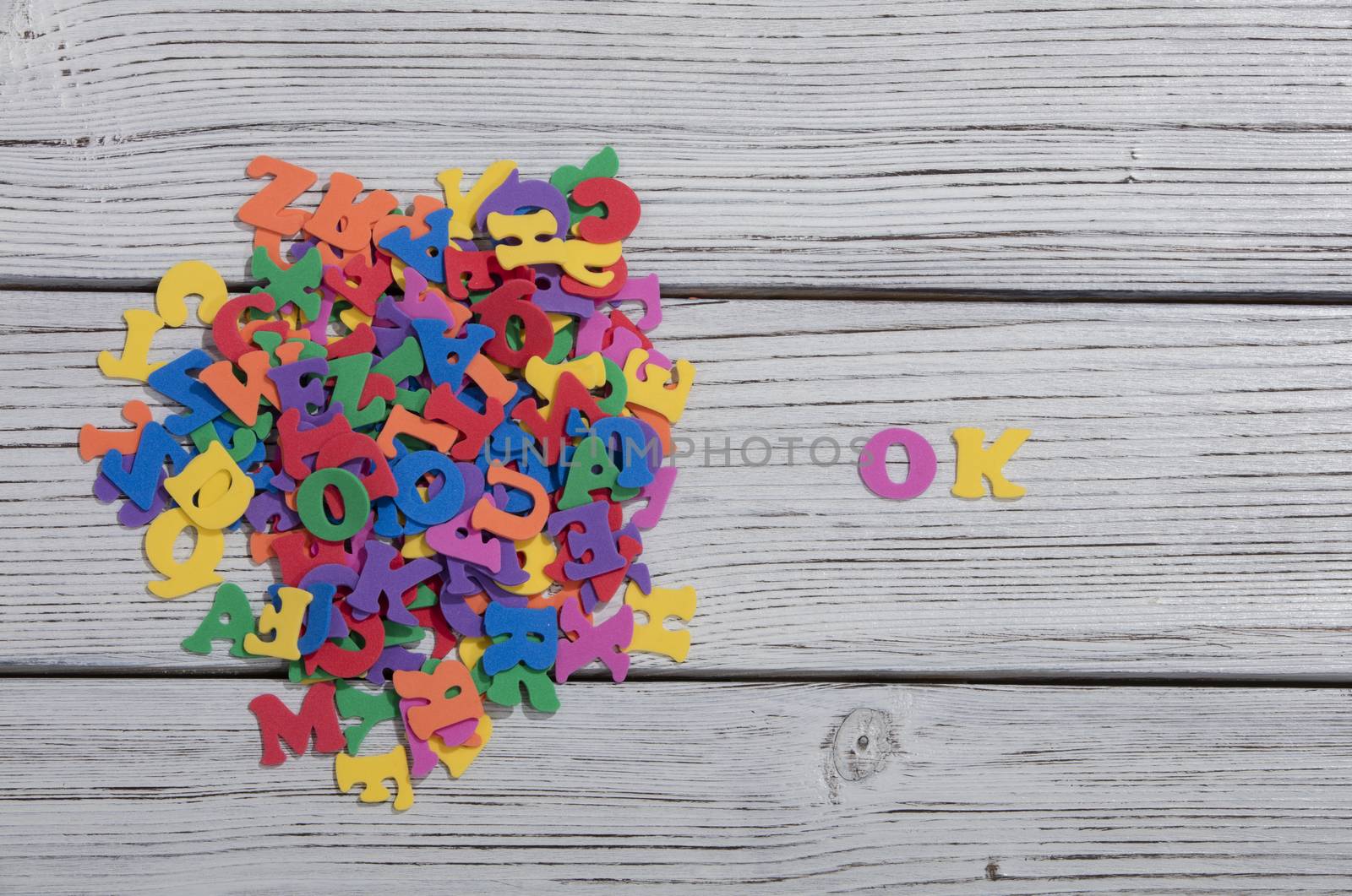 the colorful words ok made with colorful letters over white wooden board by senkaya