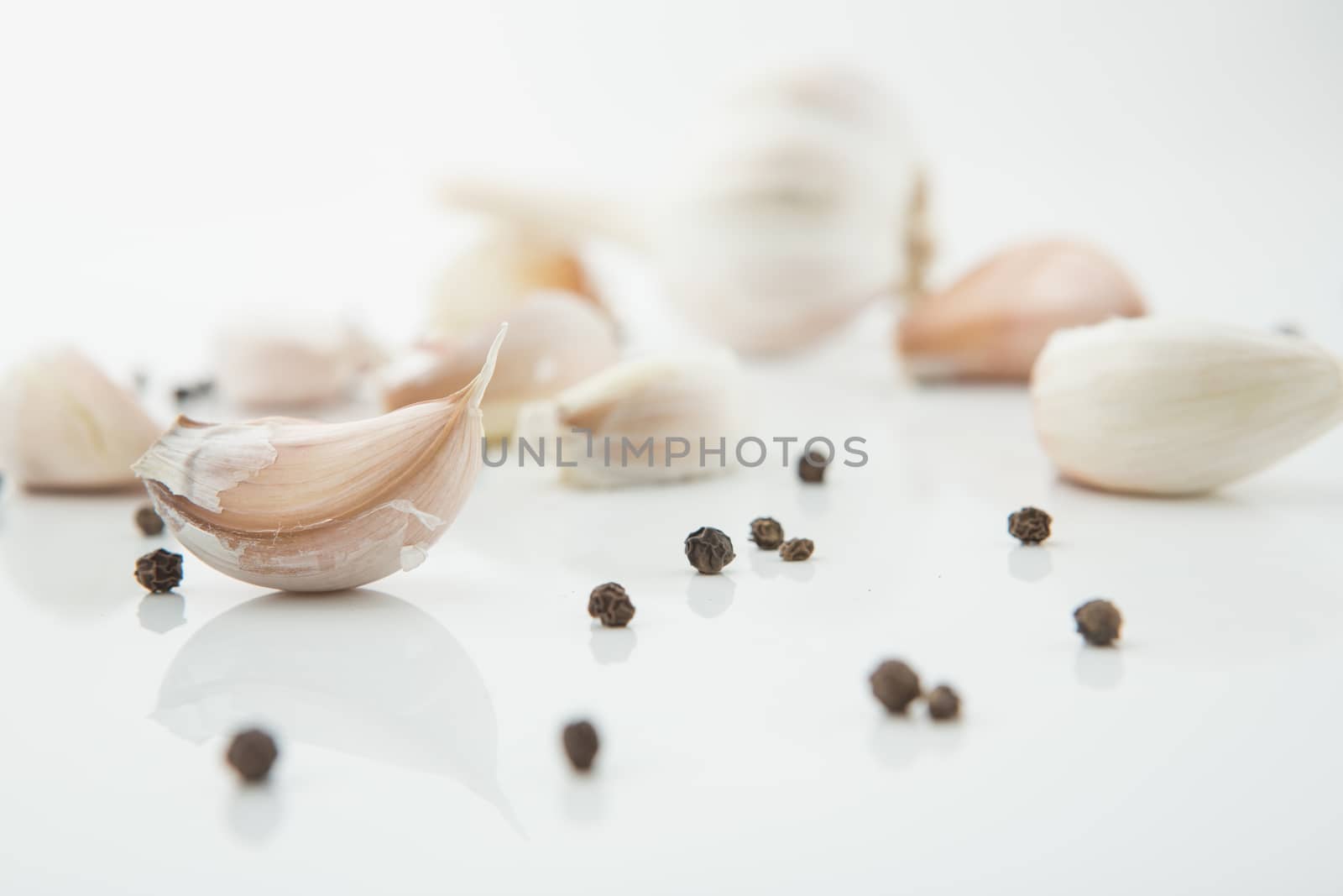 many cloves of garlic on white background,pepper