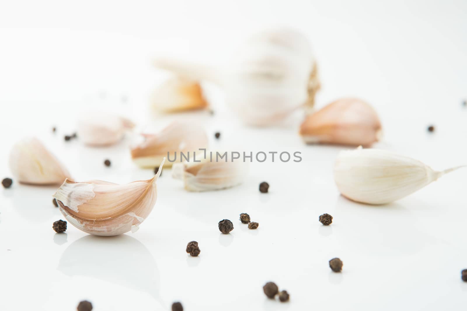 many cloves of garlic on white background,pepper