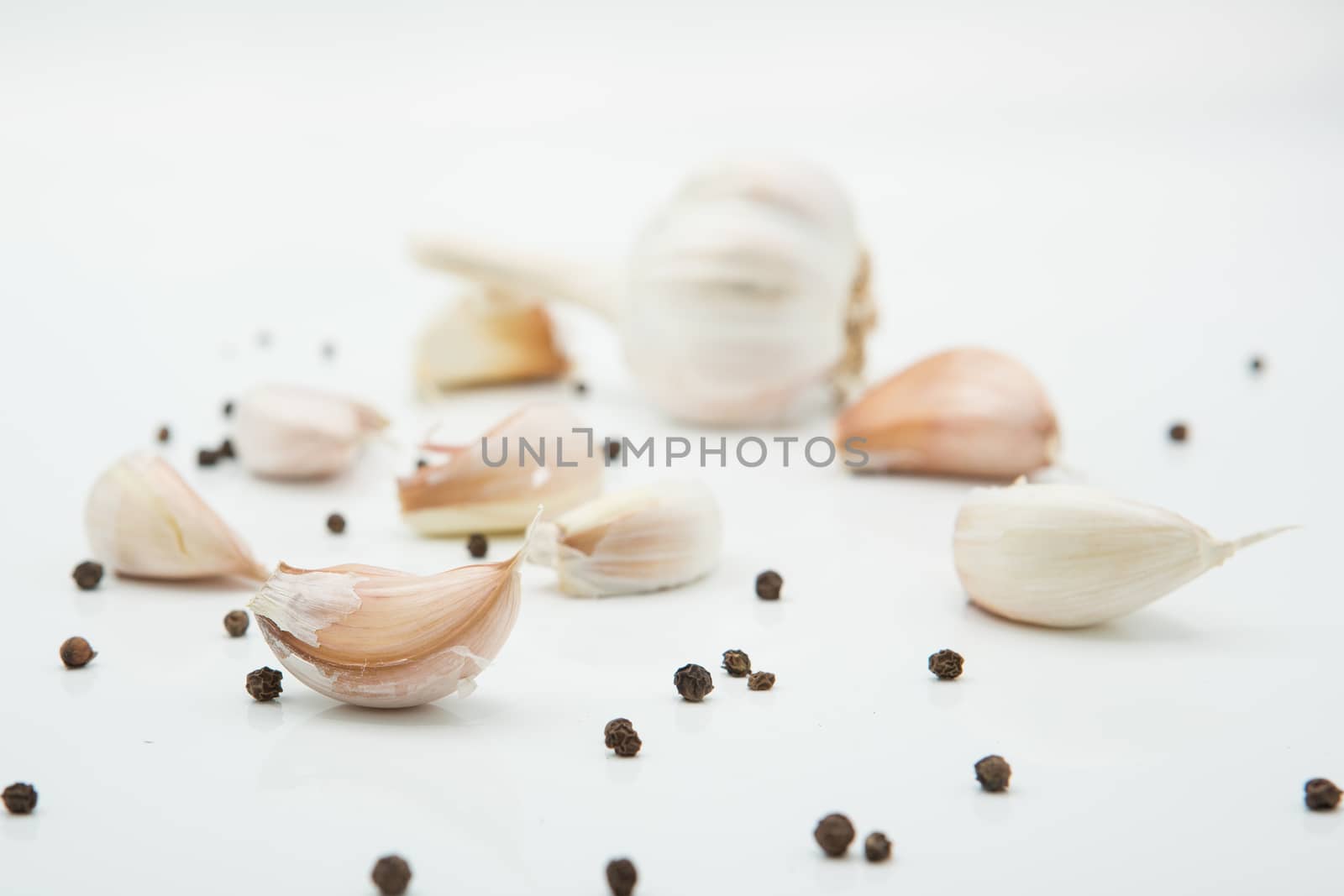 many cloves of garlic on white background,pepper