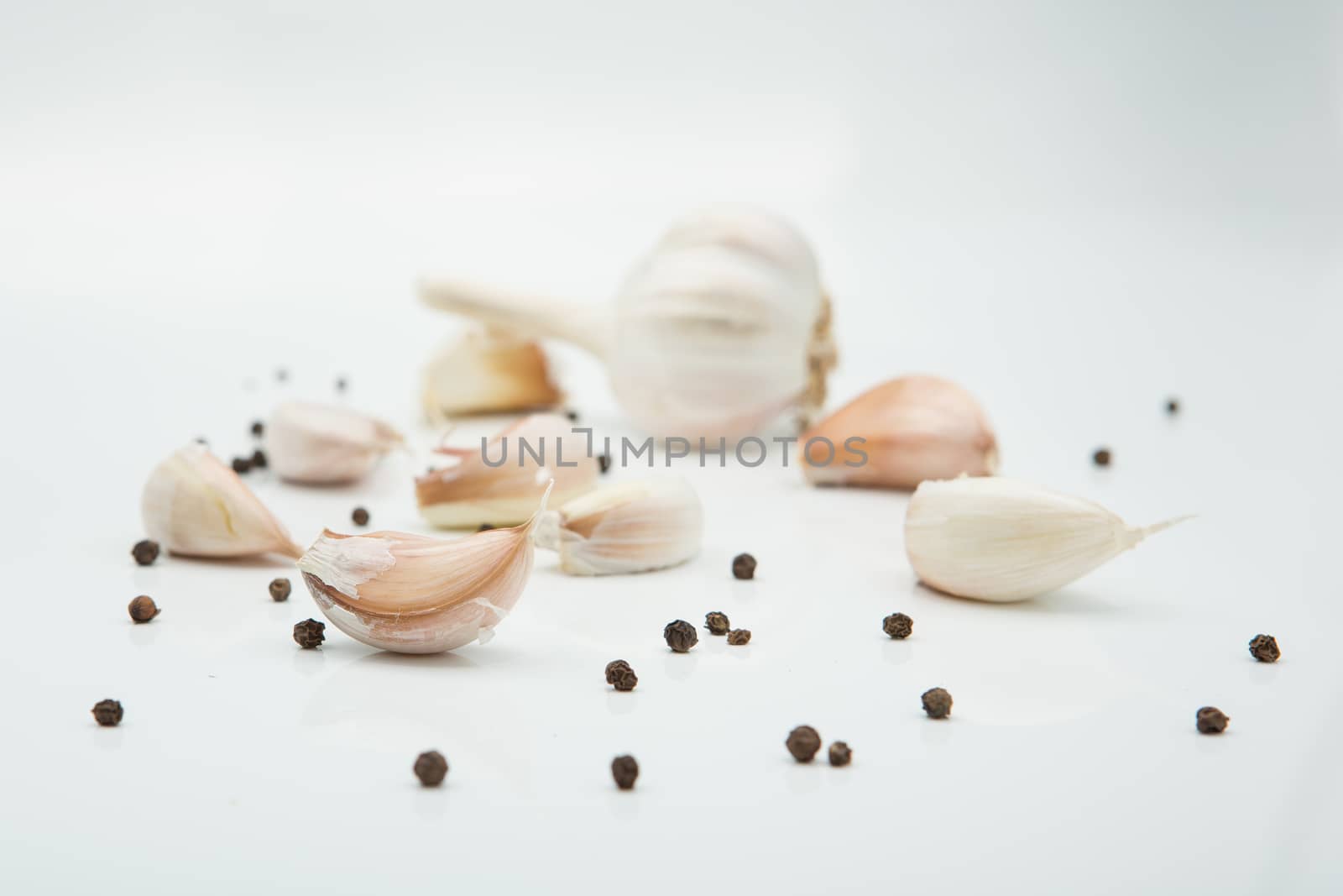 many cloves of garlic on white background,pepper