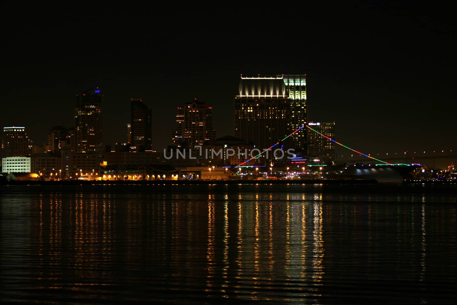 The skyline of San Diego at night with reflection in the water.