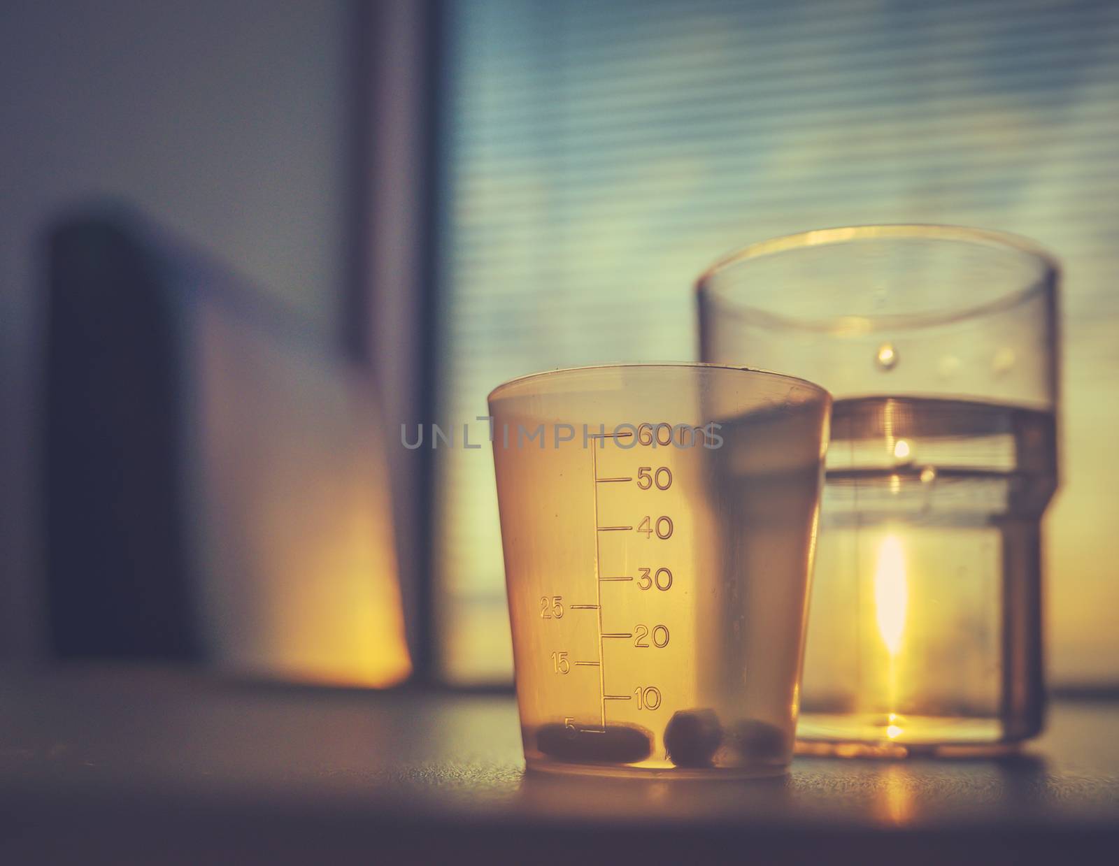 Healthcare Detail Of Some Medicine And A Glass of Water On A Table In A Hospiral Room