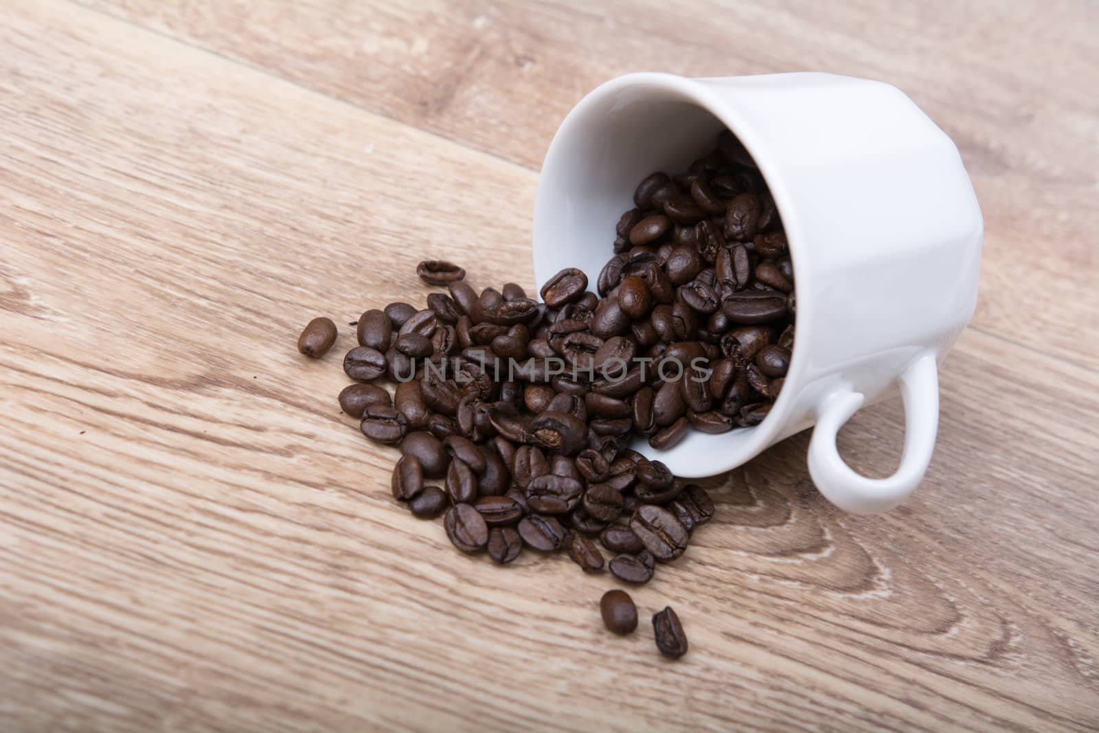 Coffee spill out of a white cup on wooden background