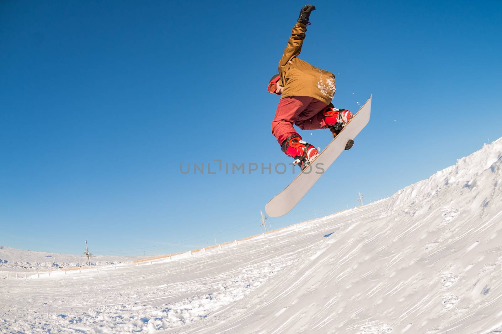 Snowboarder executing a radical jump against blue sky.