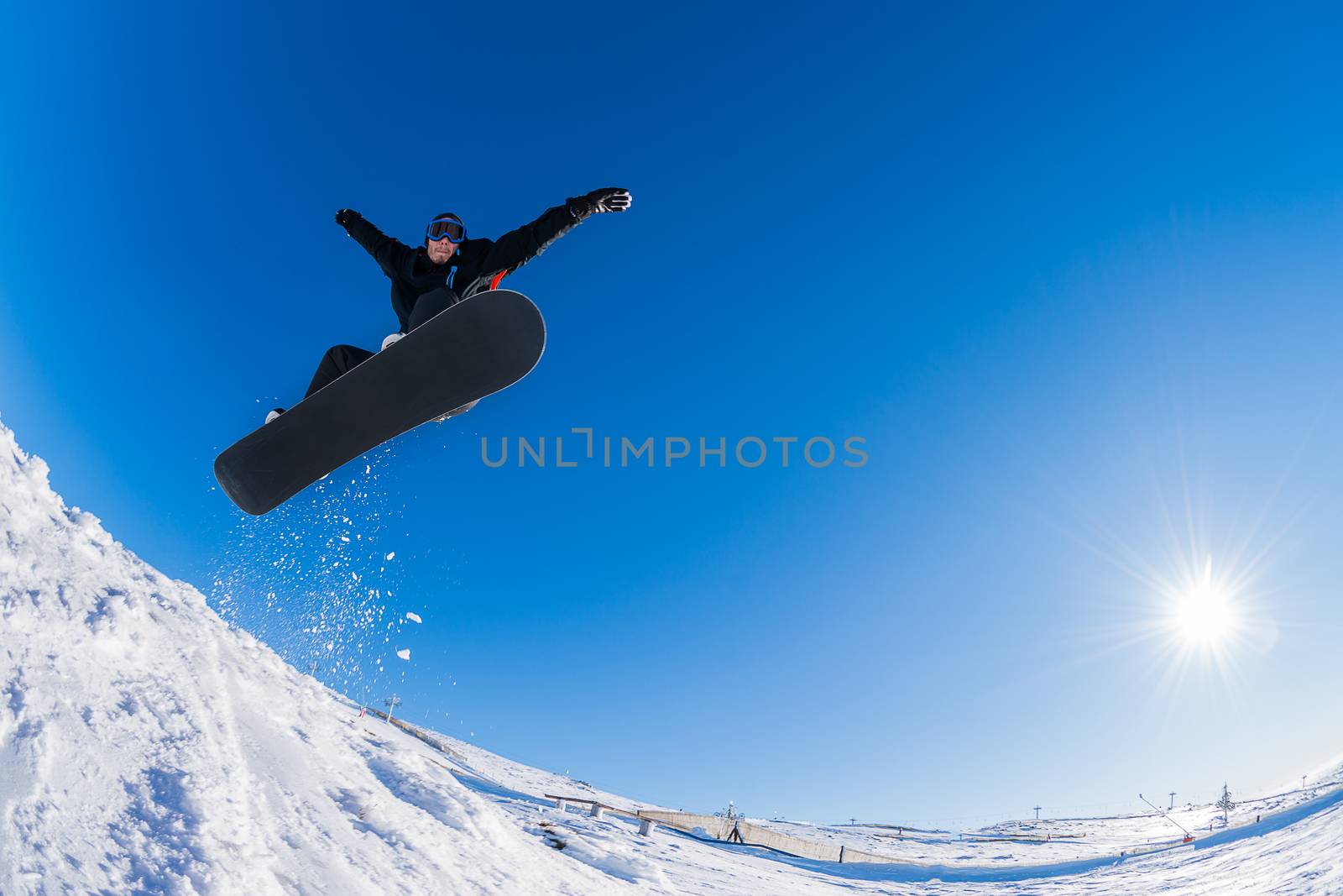 Snowboarder executing a radical jump against blue sky.