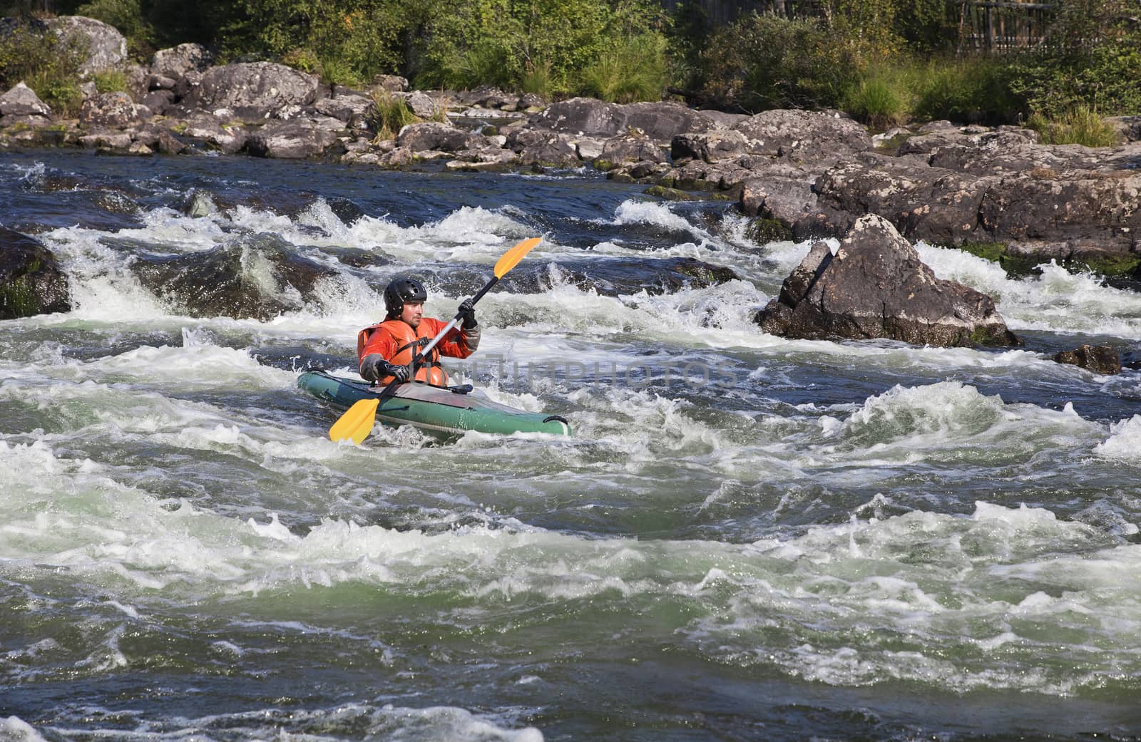 Kayaker in the  whitewater of a river Umba in Russia