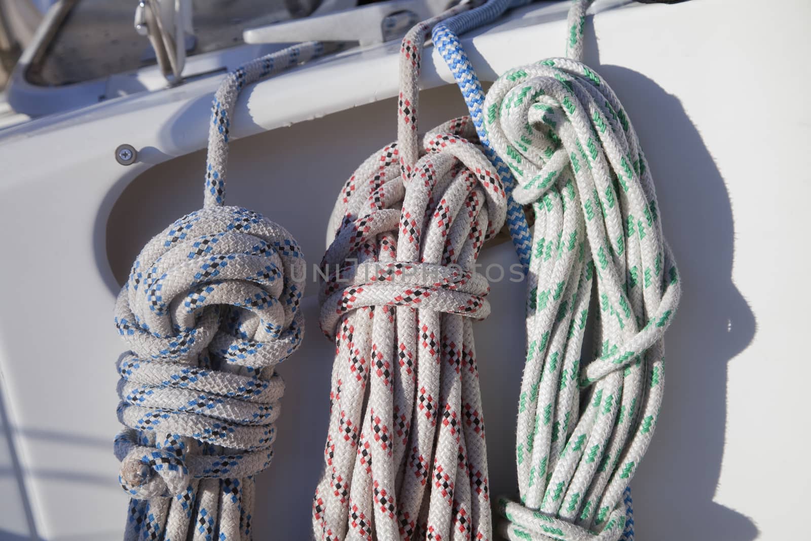 Colorful ropes hanging on yacht railings, closeup