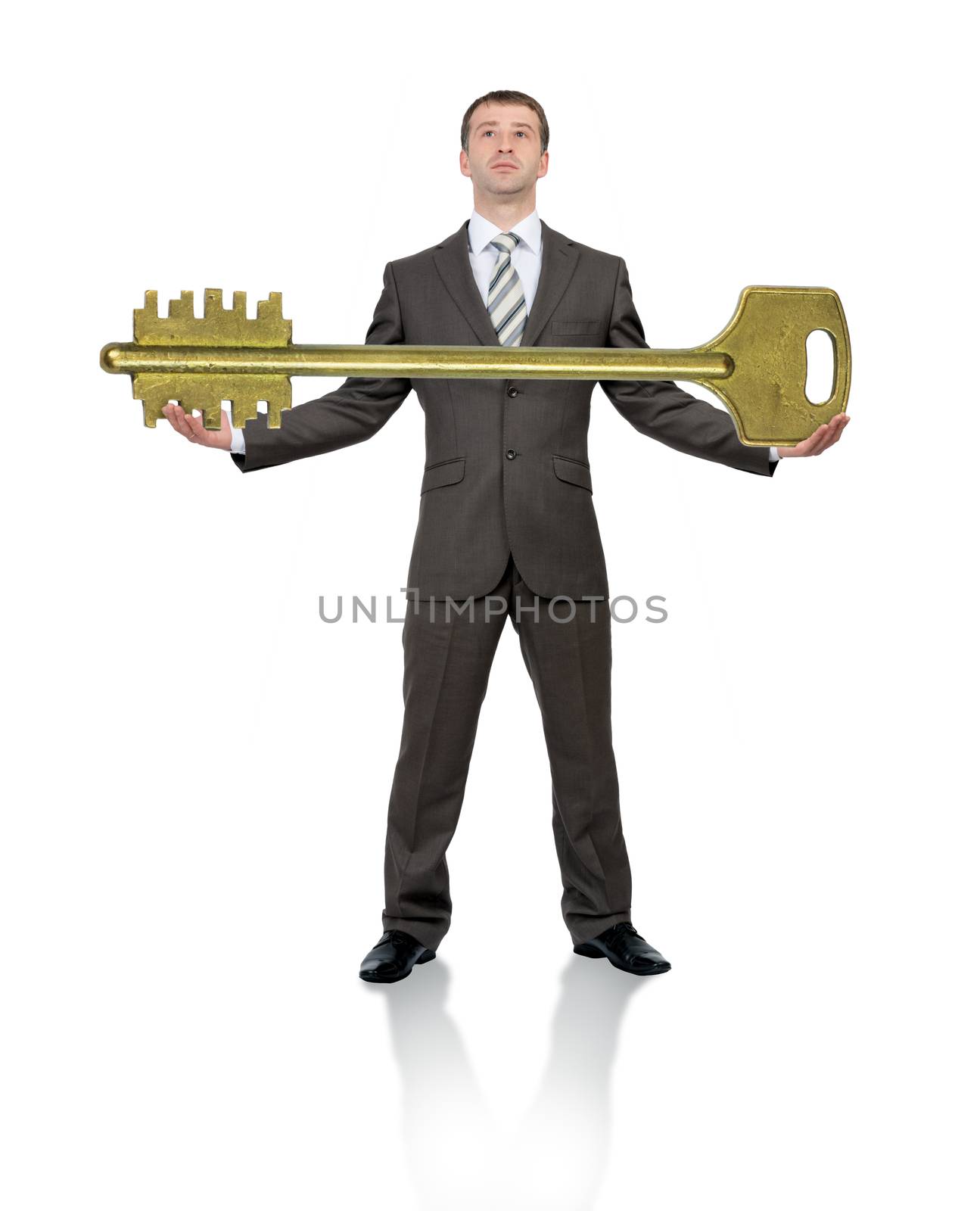 Businessman holding big gold key by cherezoff