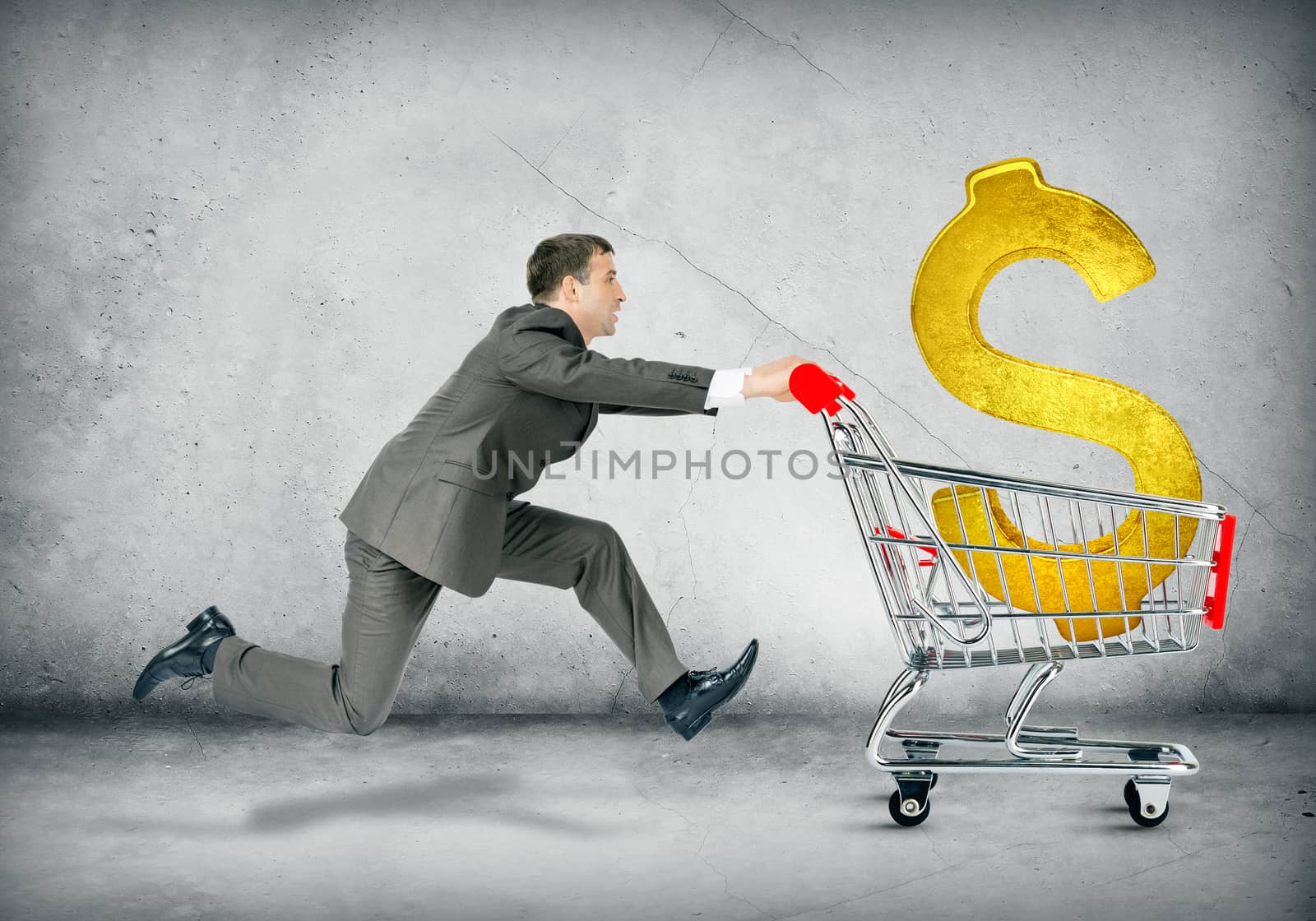 Businessman pushing shopping cart with dollar sign on grey background