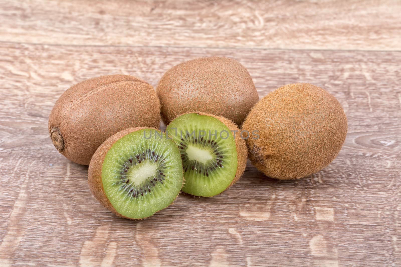 Ripe kiwi on a brown wooden background