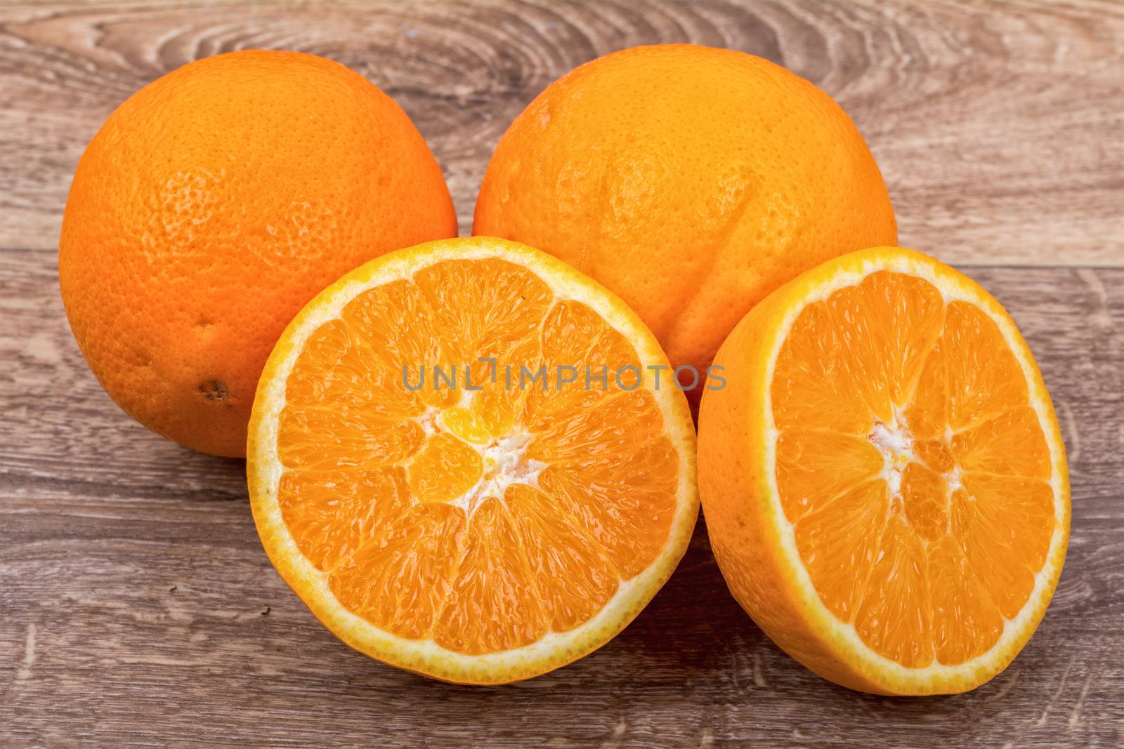 The orange oranges on a brown wooden background