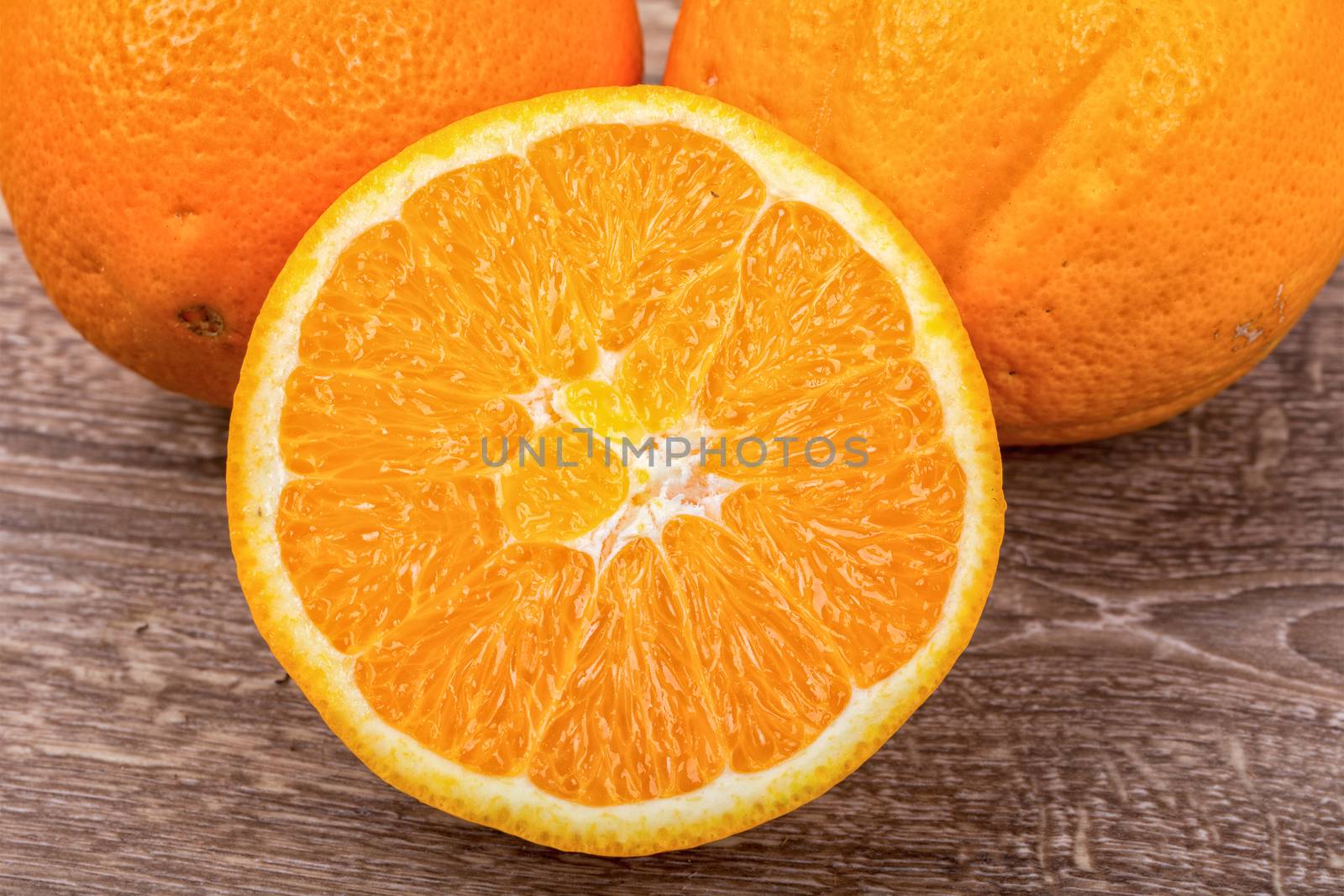 The orange oranges on a brown wooden background
