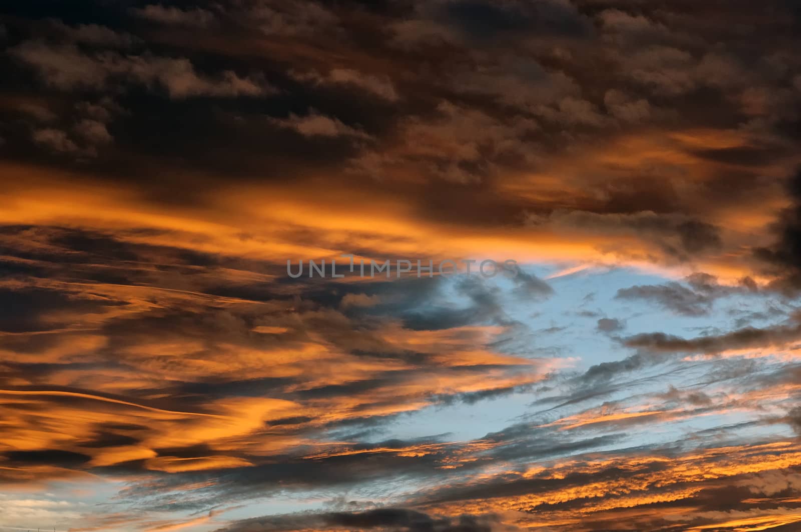 Nice clouds at sunset with orange black color.