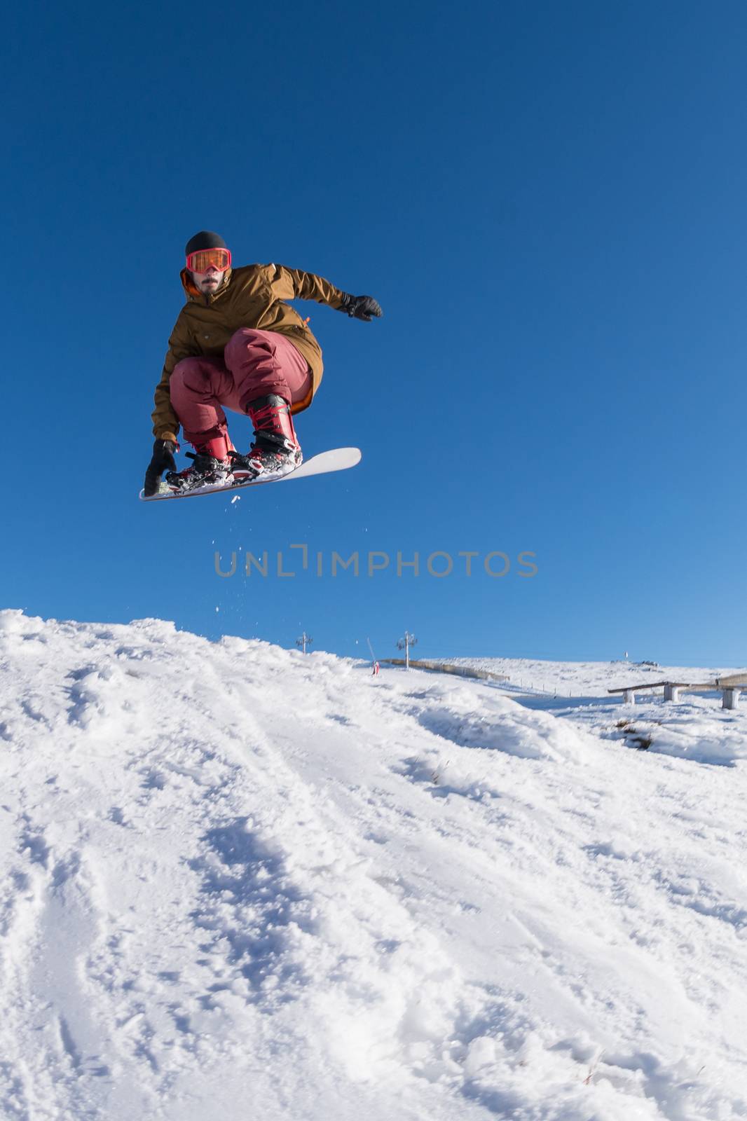 Snowboarder executing a radical jump against blue sky.