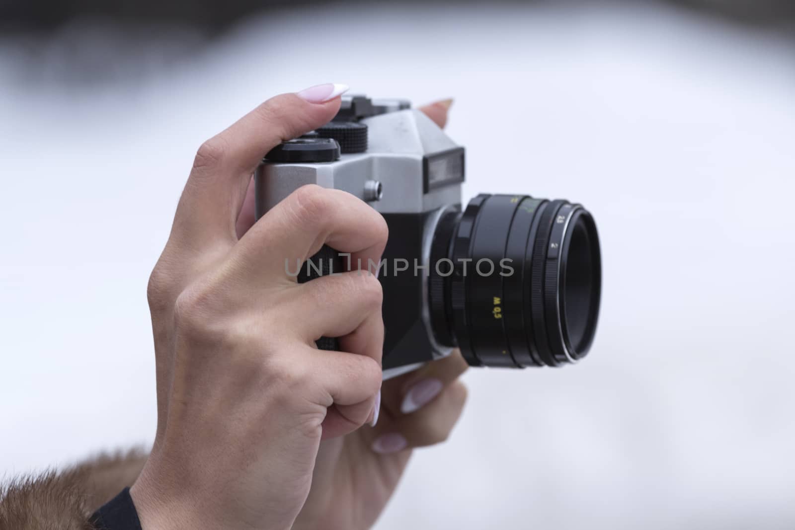 girl holding an old camera on a white premise