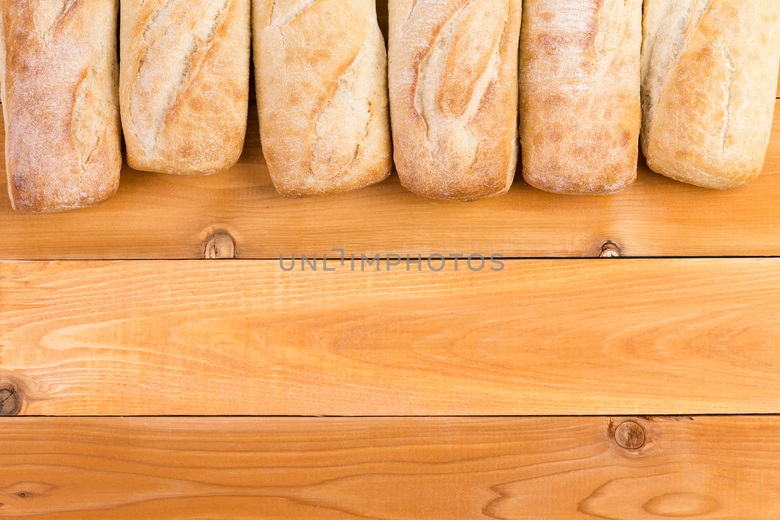 Crusty fresh bread loaf border on wood by coskun