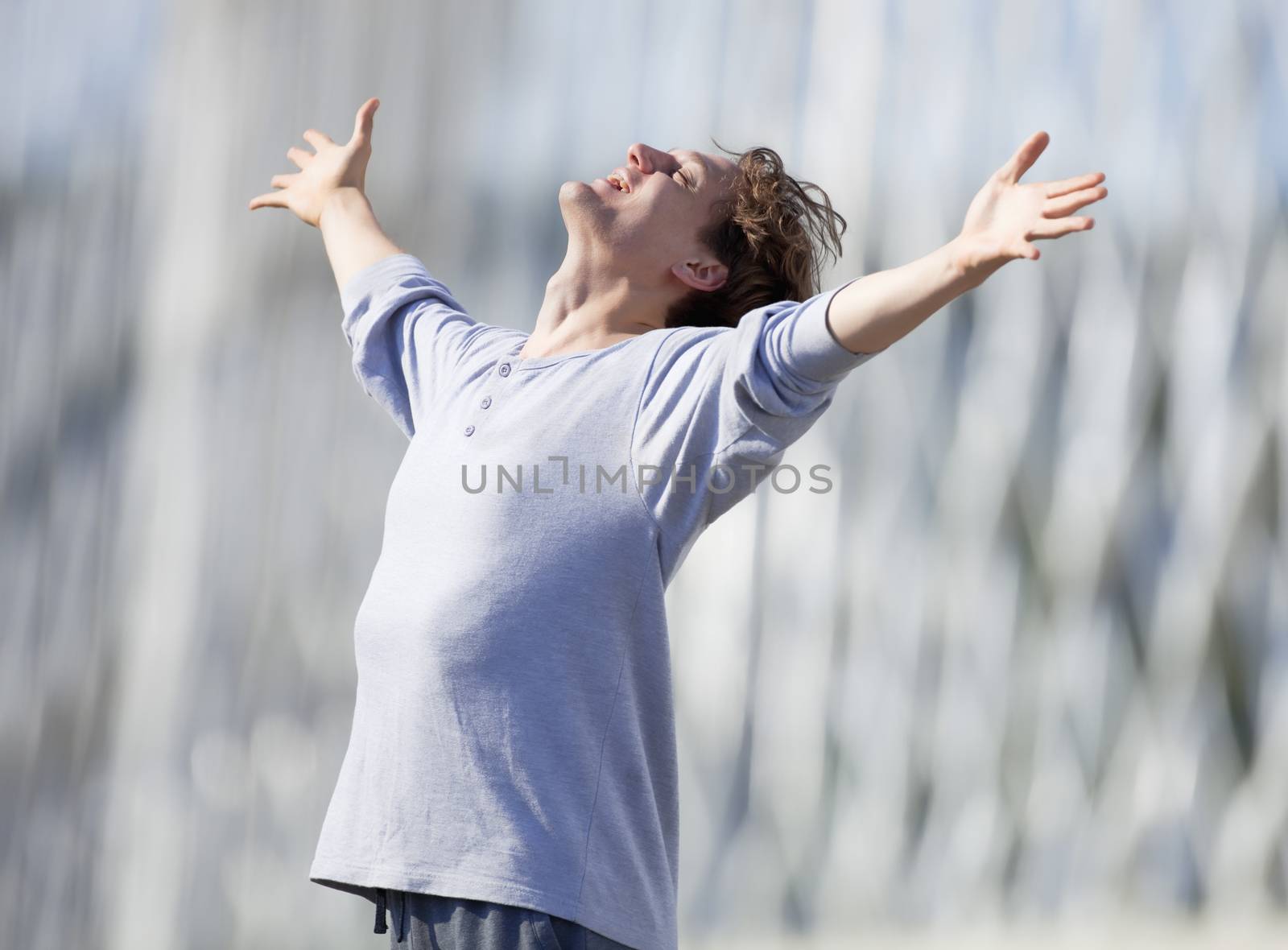 Excited Young Man Stretching out his Arm in Emotion Outdoors