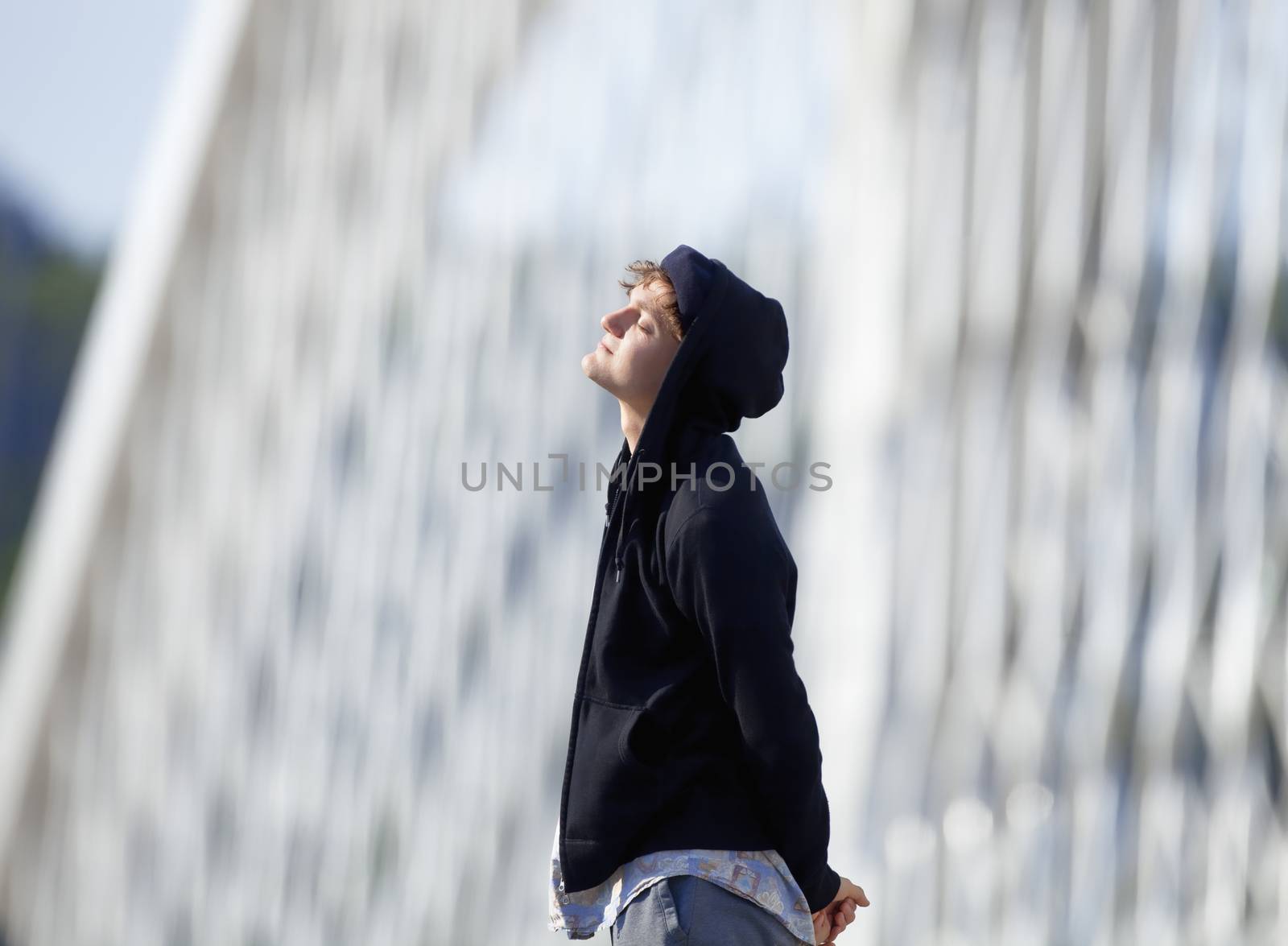 Young Man with Hood Standing on the Bridge by courtyardpix