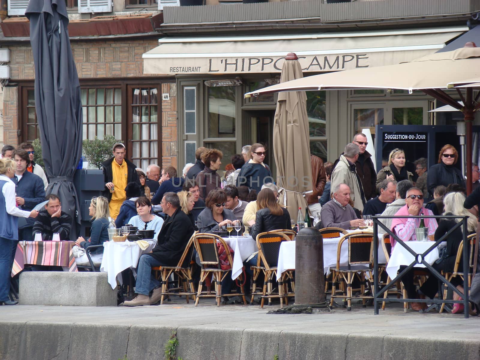 Honfleur, France - May 9 2010: People Sitting on the Terrace of the Restaurant. Port of Honfleur in the Calvados department in northwestern France