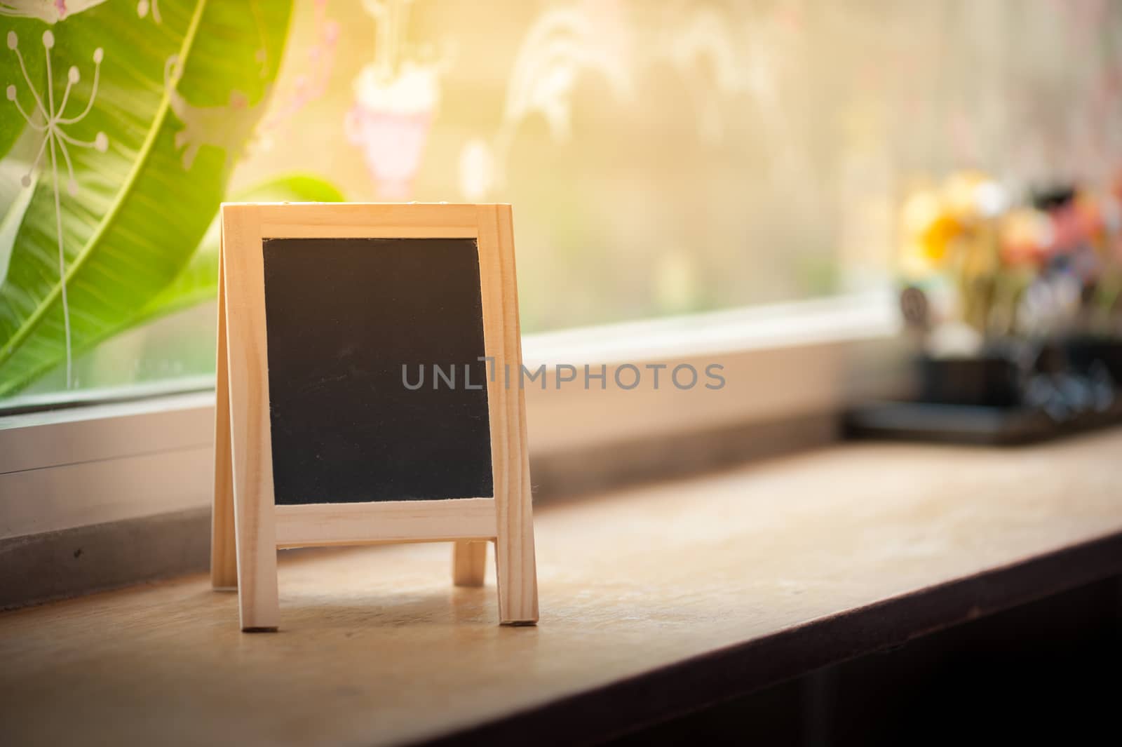 Small A-frame black board with blank area for text or message on wood bar in cafe