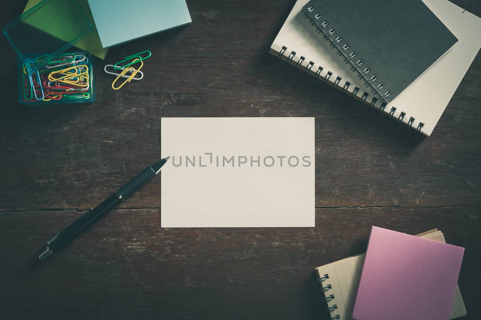 Notepad with blank area for text or message on wood table with low key scene and vintage filter effect