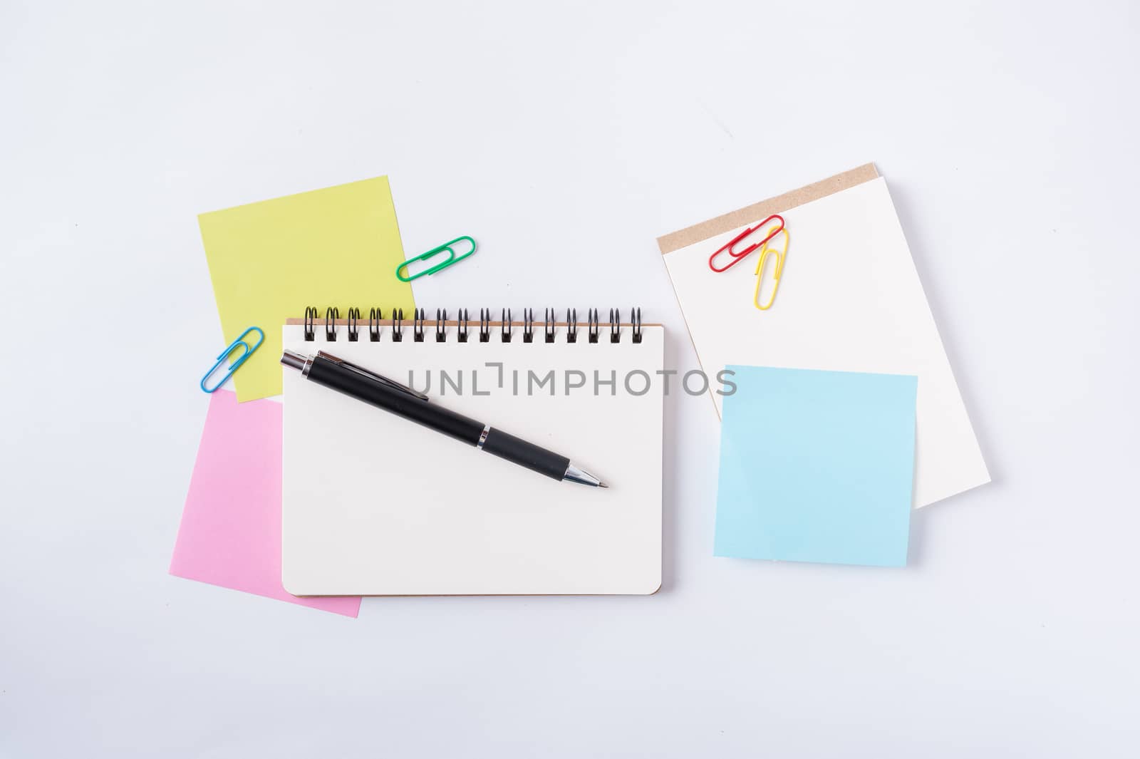 Opened notebook with blank space for text or message, sticky paper, and pen on office table