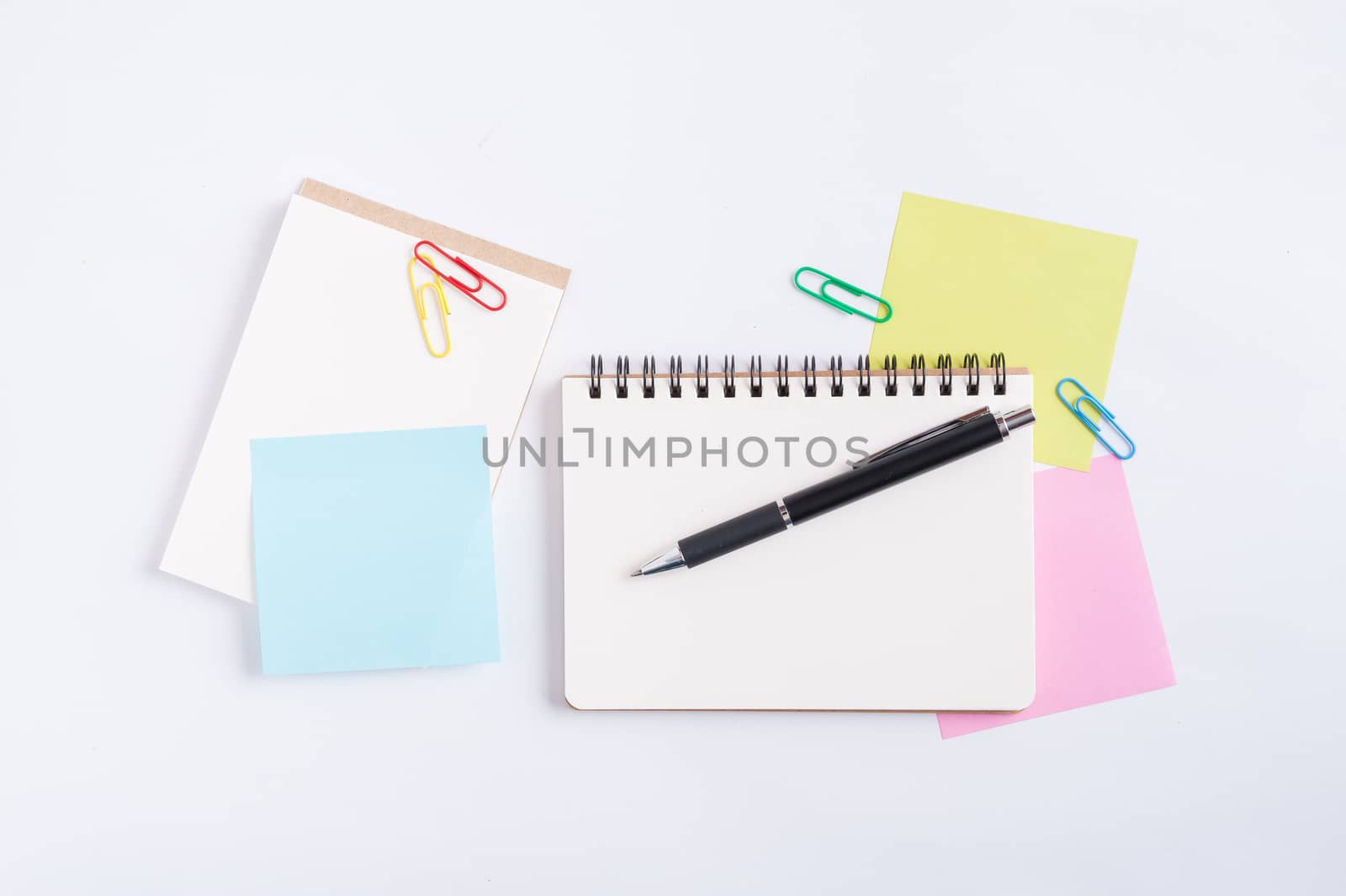 Opened notebook with blank space for text or message, sticky paper, and pen on office table