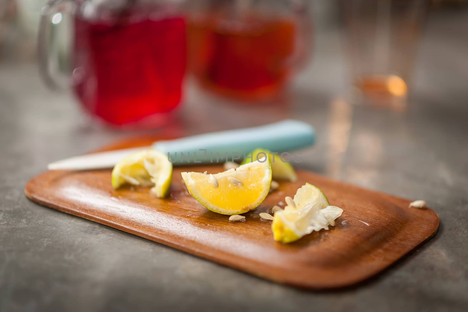 Pieces of sliced lemon on wood board on concrete bar in cafe with low key scene