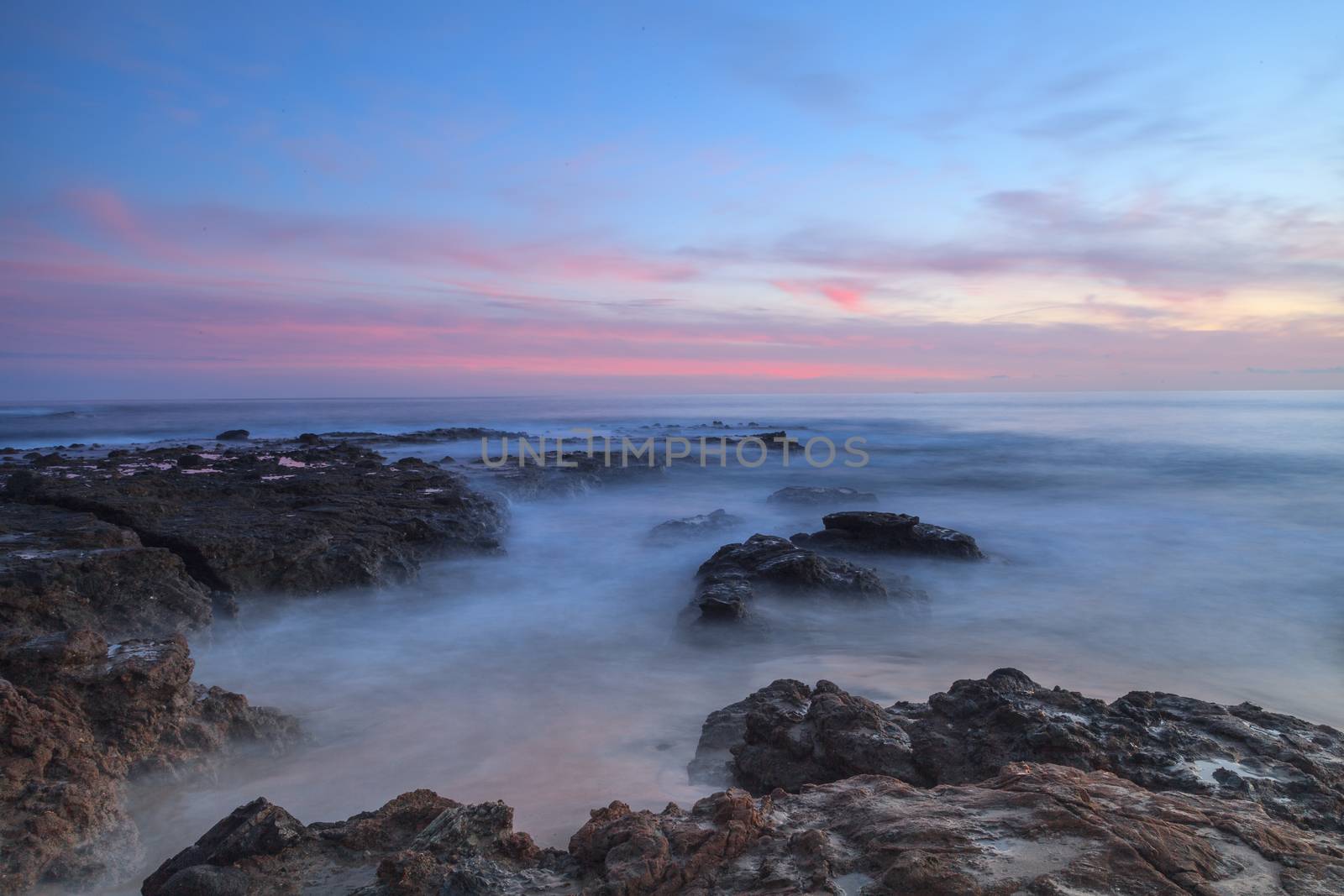 Long exposure of sunset over rocks by steffstarr