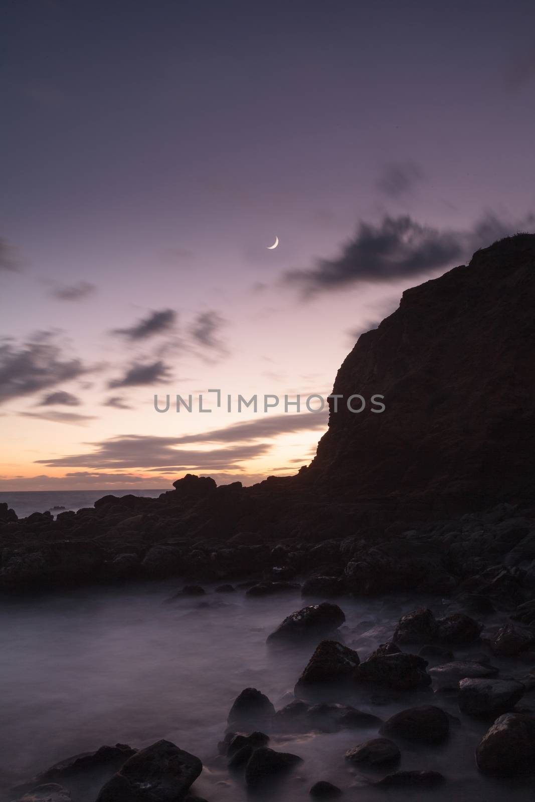 Moonset and sunset at Crescent Bay beach in Laguna Beach, California, United States