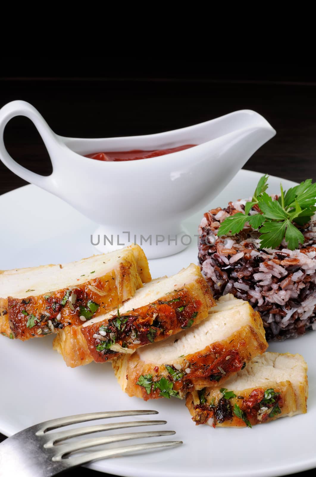 Slices of roasted chicken breast with a side dish various of rice with  sauce