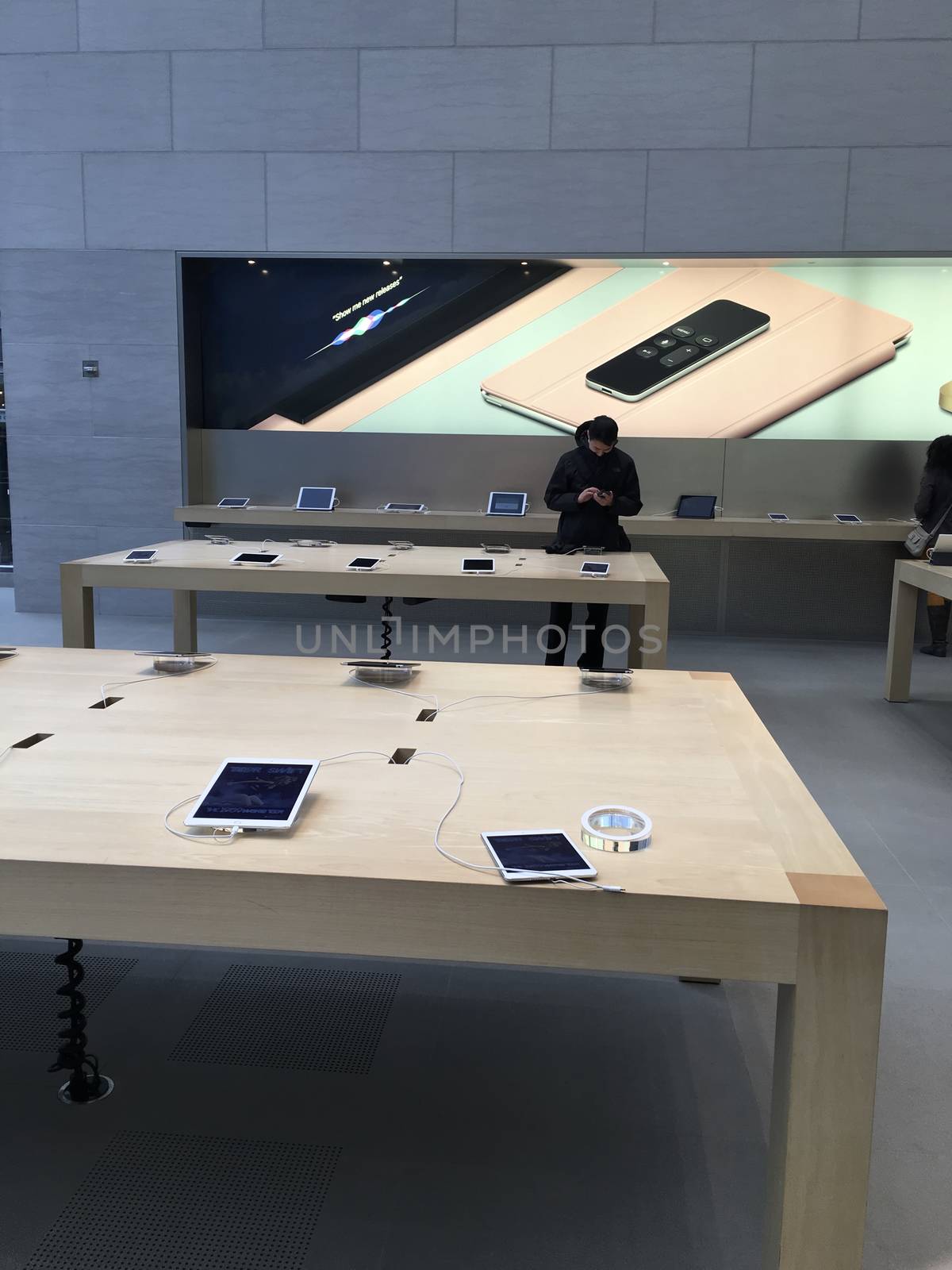 Shopping inside Apple Store in New York City, UNITED STATES AMERICA - FEB 23 2016: New Apple products , iPad Pro displayed on wooden tables for use in New York, USA