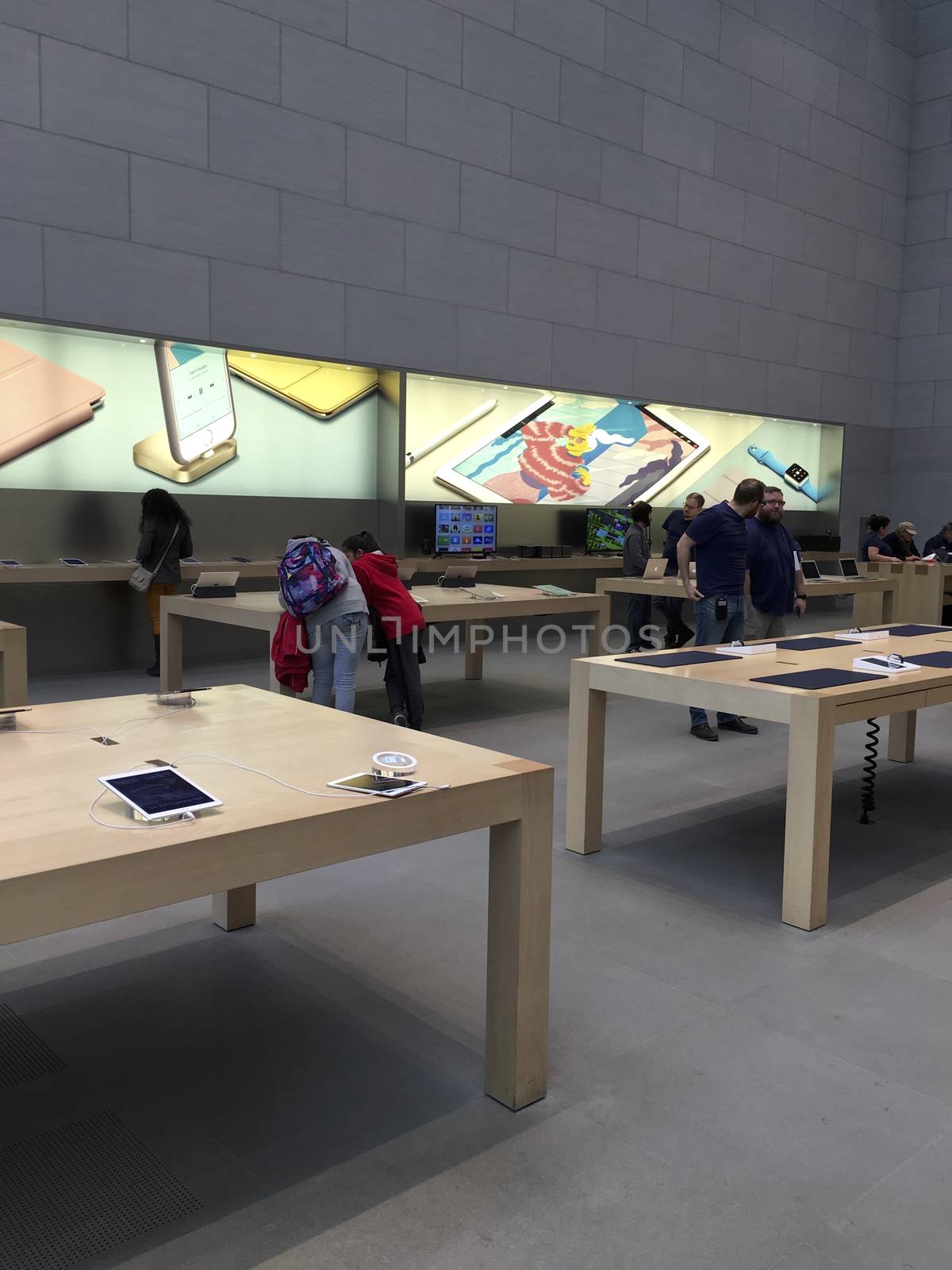 Shopping inside Apple Store in New York City,  UNITED STATES AMERICA - FEB 23 2016: New Apple products , iPad Pro displayed on wooden tables for use in New York, USA
