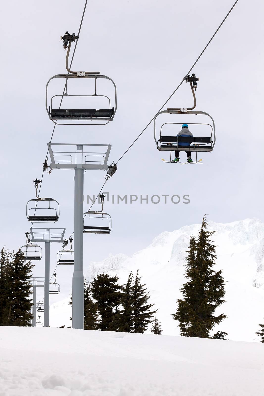 Skier Riding Ski Lifts up the slope of Mount Hood Oregon during Winter Skiing Season