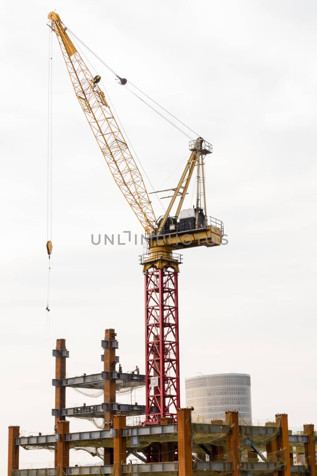 Big building being constructed with crane on top