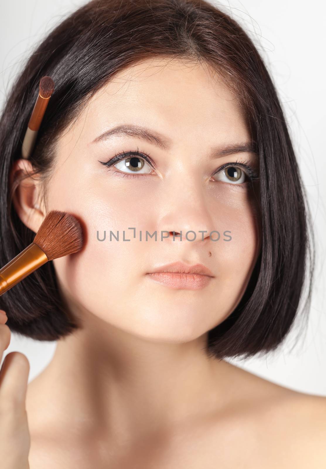 the girl does make-up on a white background