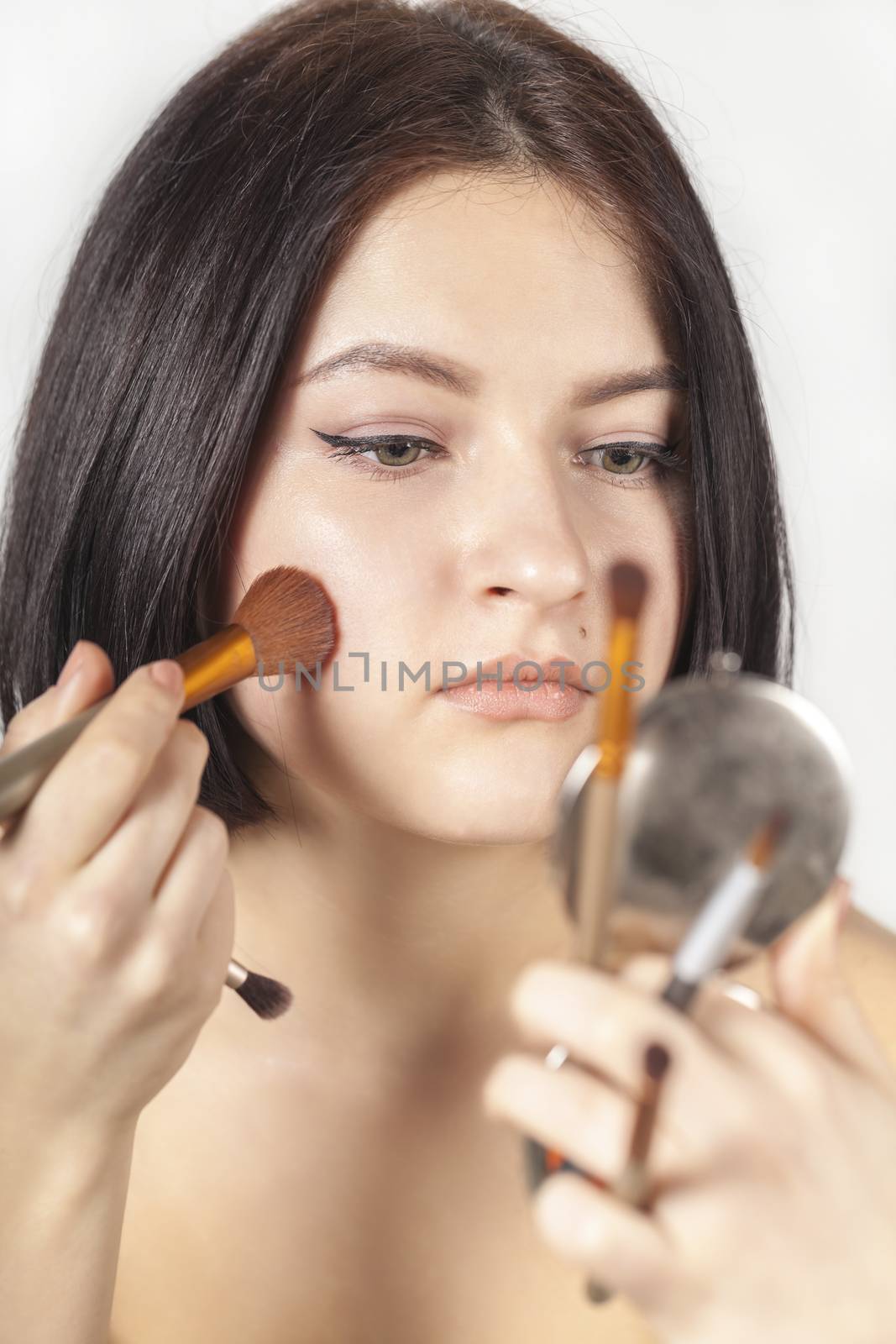 the girl does make-up on a white background