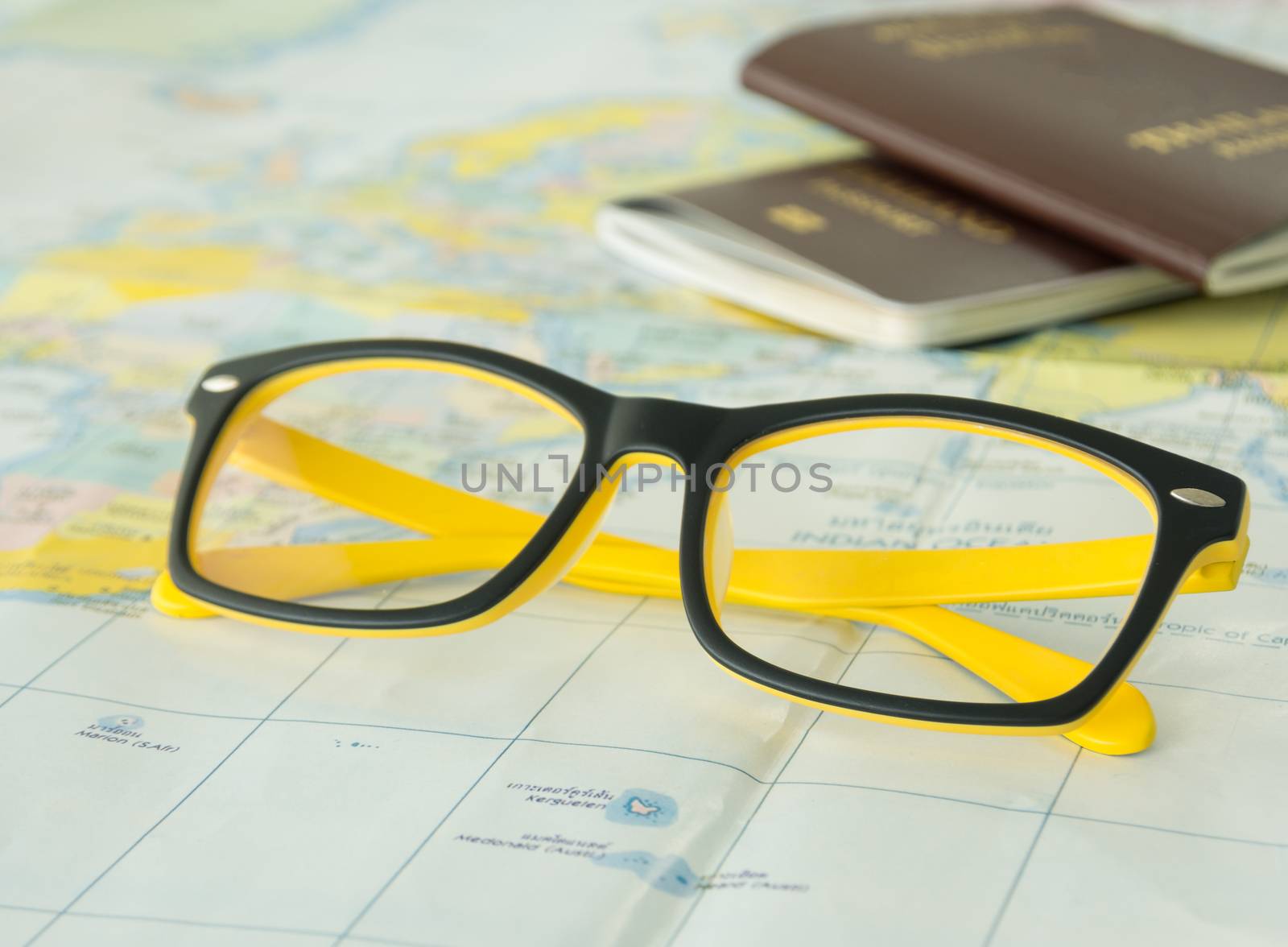 closeup glasses on world map with passport