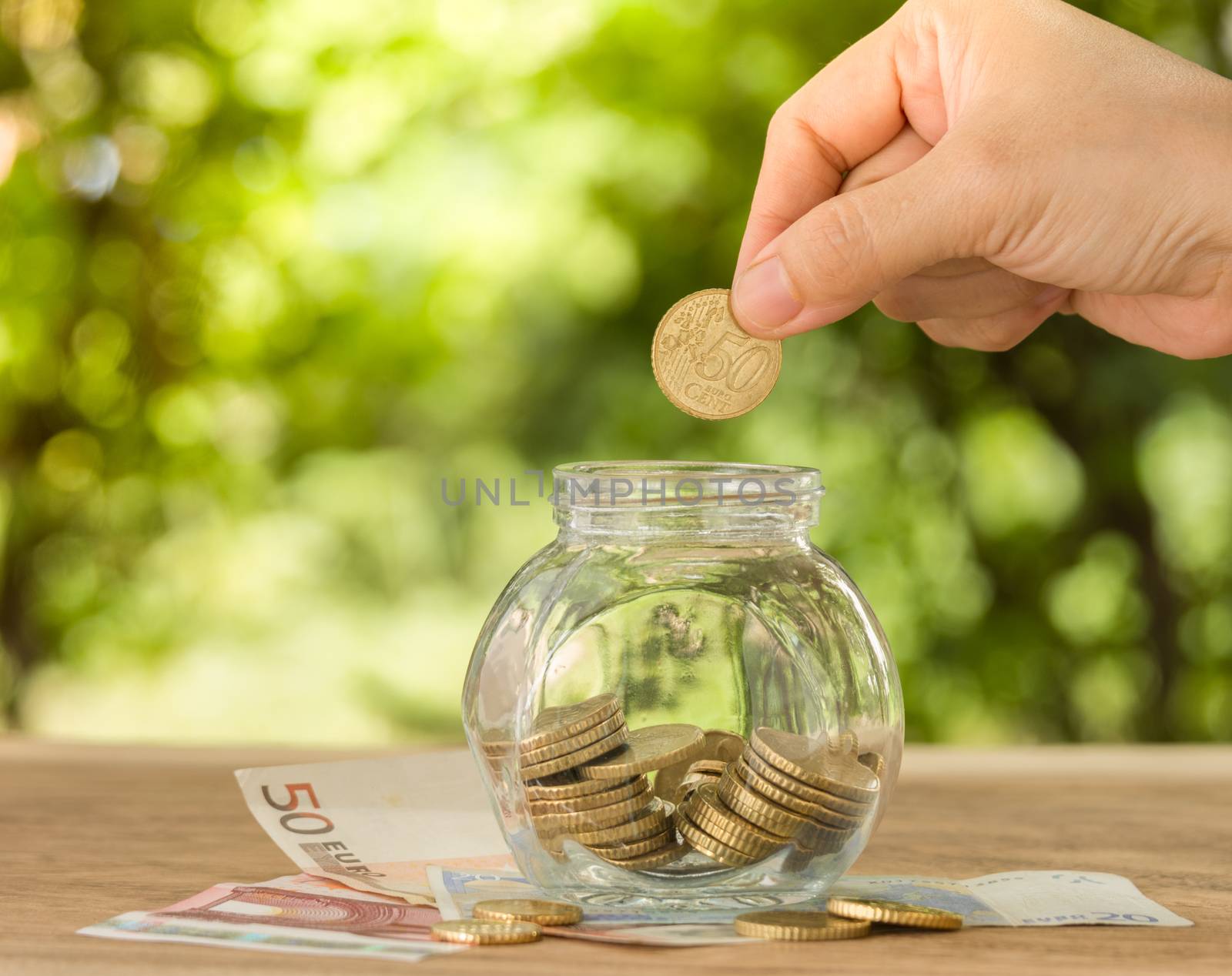 hand's women putting golden coin in money jar. account concept,business concept,finance concept.
