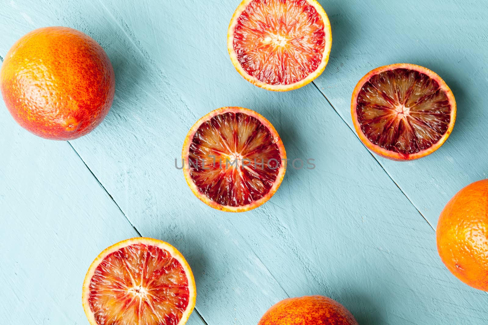 Several sanguine oranges on blue wooden background by andongob