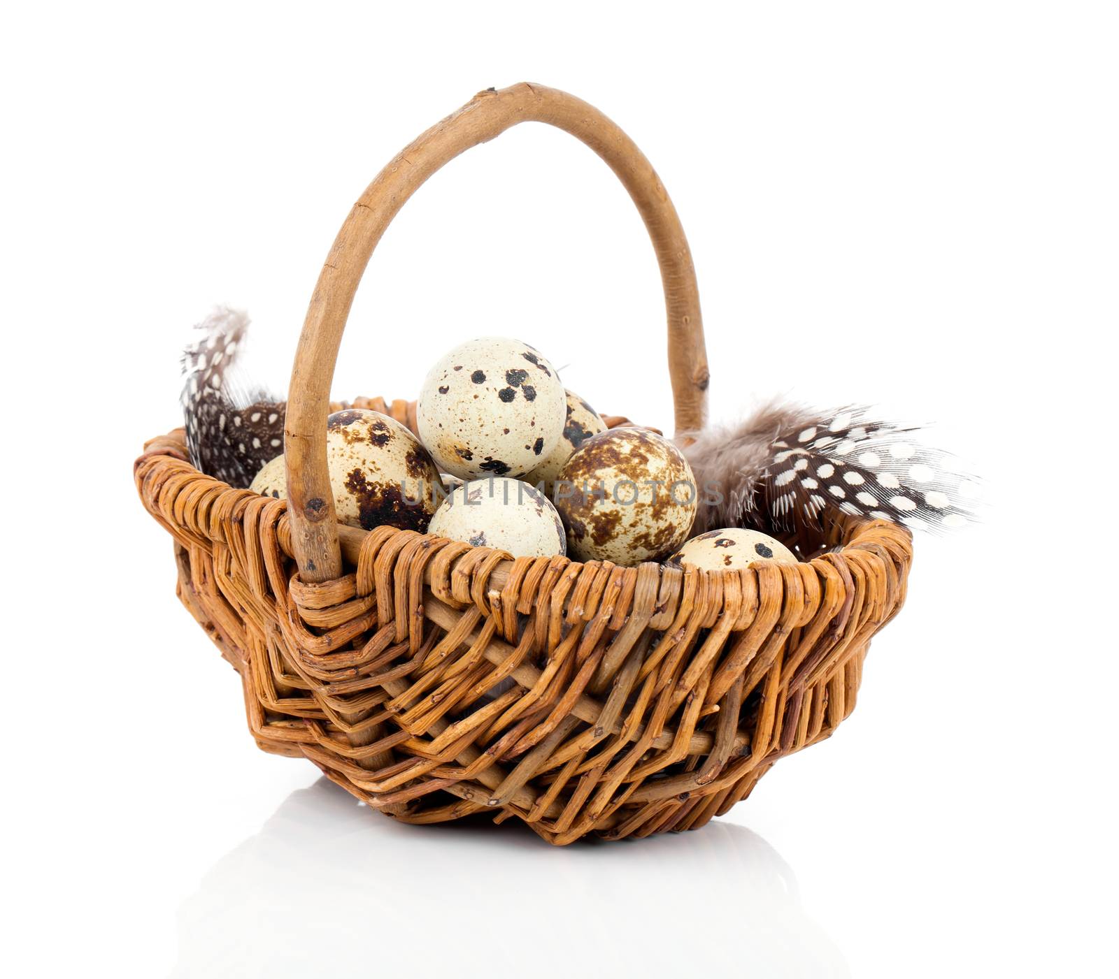 quail eggs in a wicker basket on white background