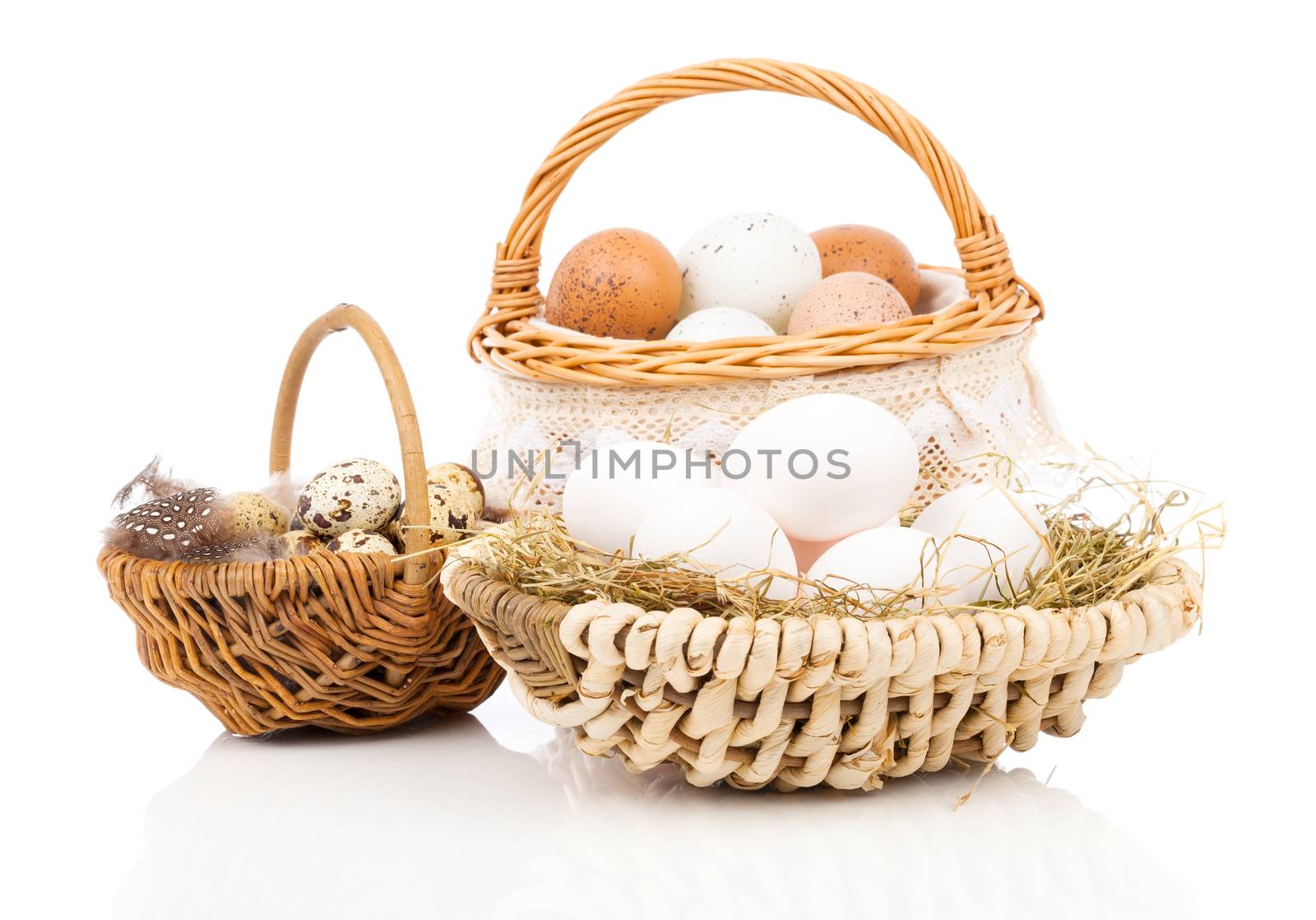 chicken eggs and quail eggs in basket, on white background by motorolka