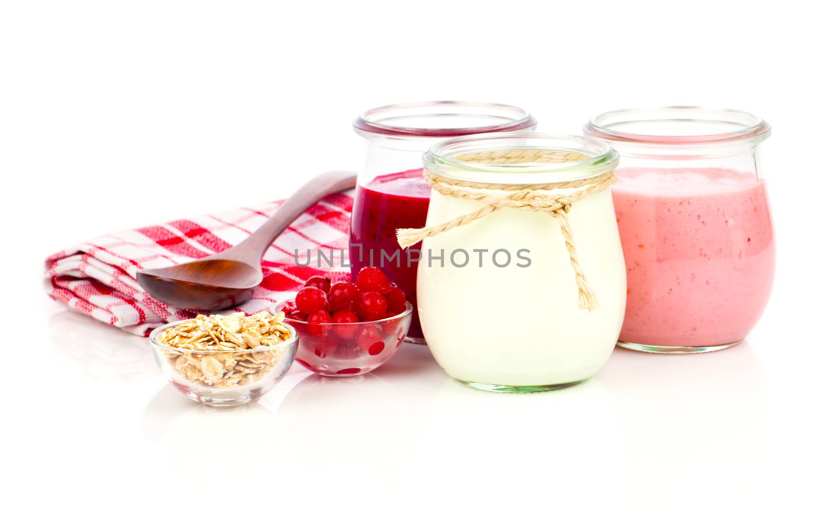 Delicious, nutritious and healthy yogurt in a glass jars with spoon on a white background
