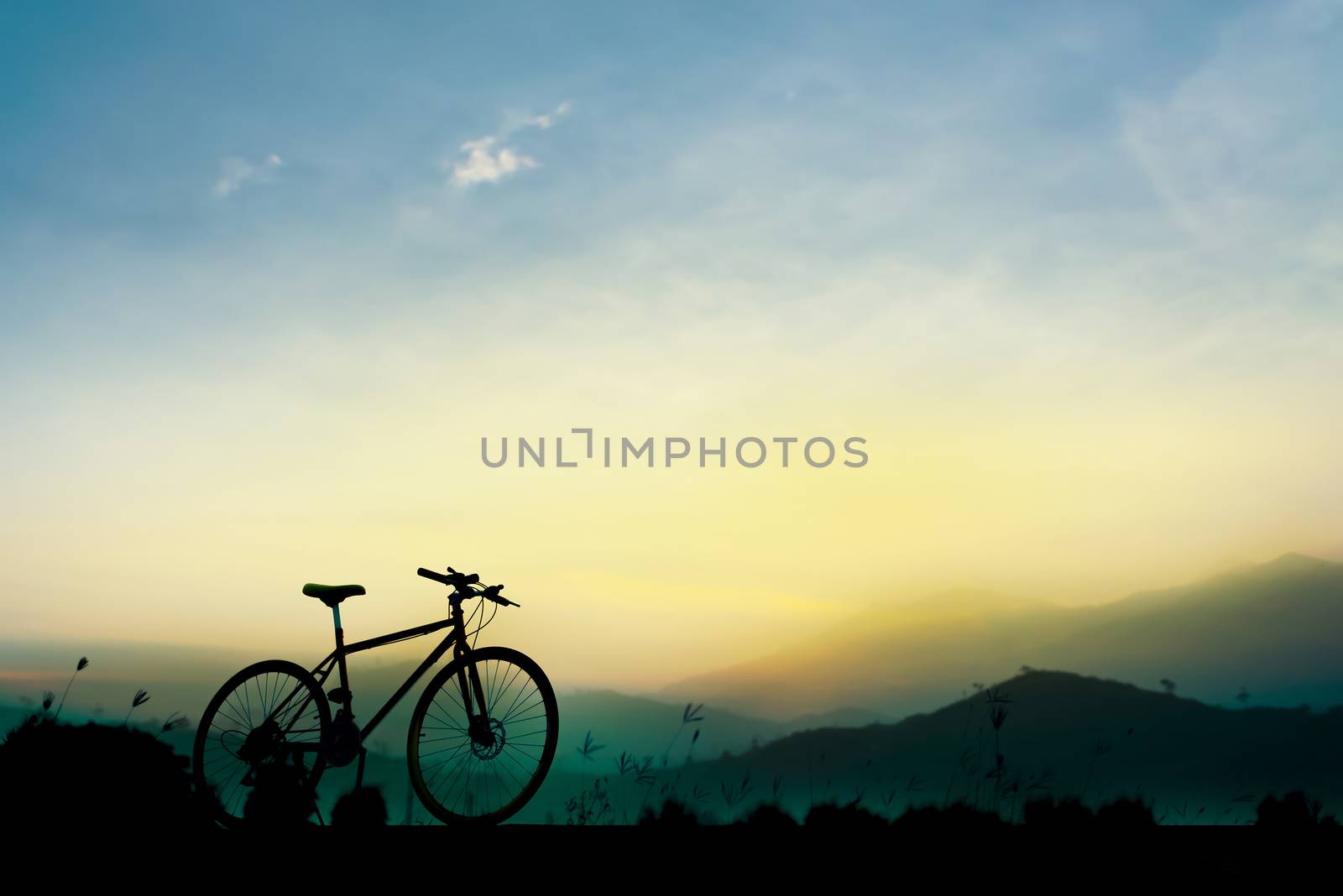 Sunset silhouette and bicycle on beautiful sky by anatskwong