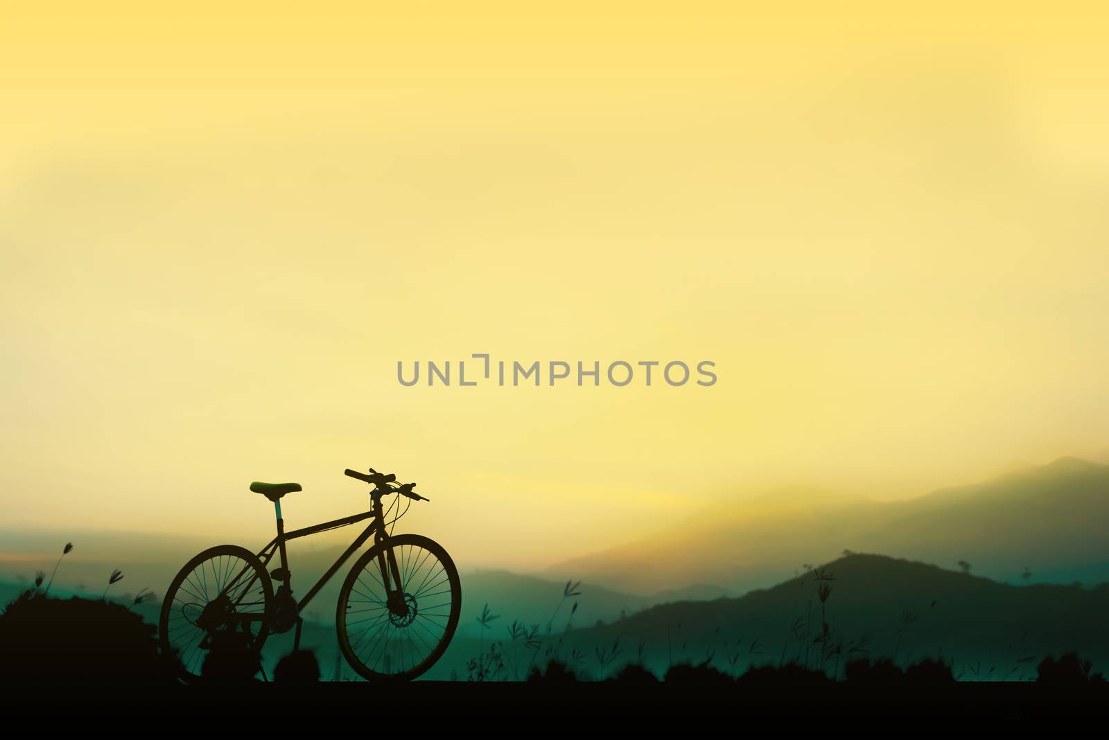 Sunset silhouette and bicycle on beautiful sky