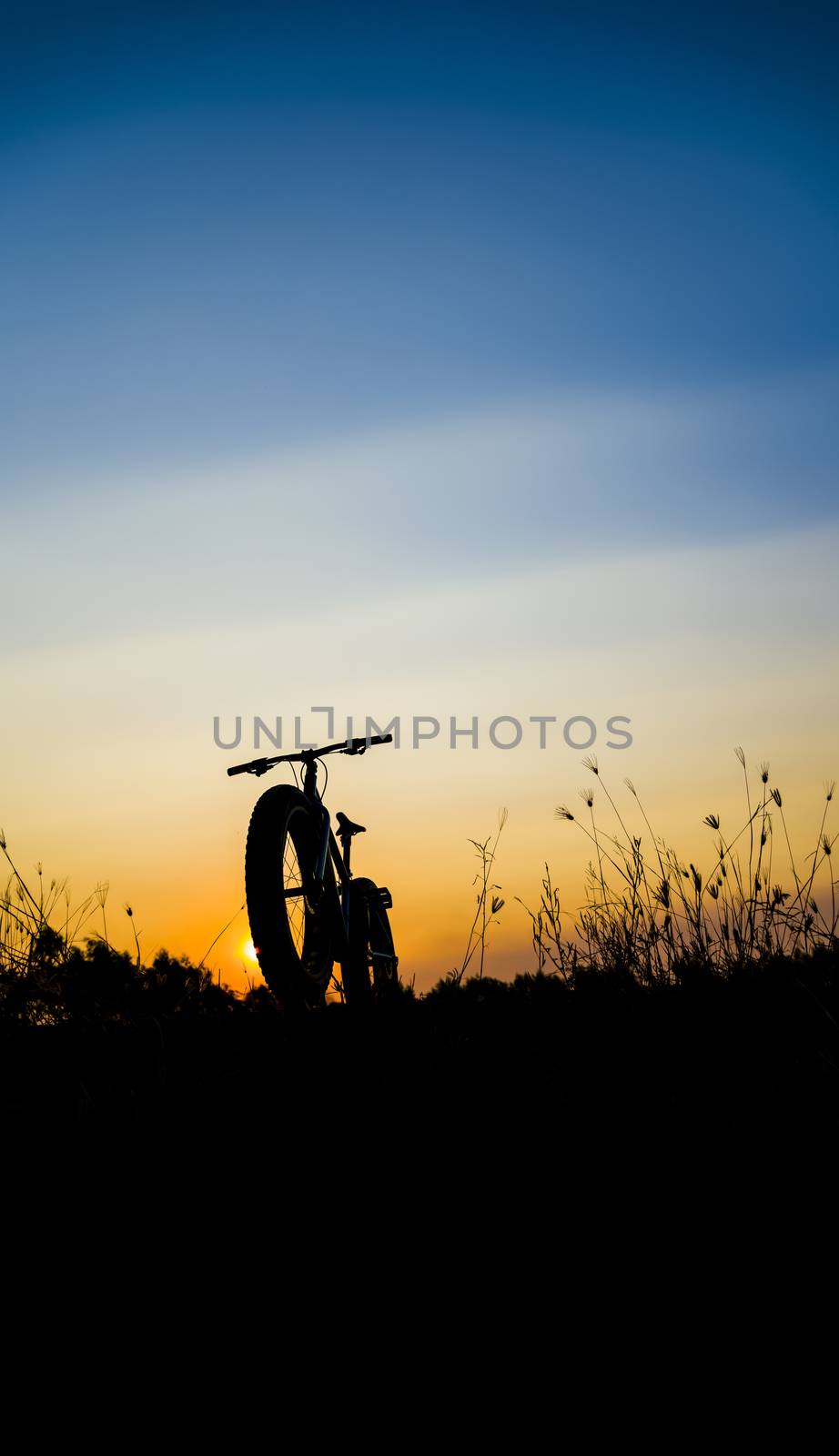 beautiful sunset sky and mountain bike silhouette , silhouette fat bike by anatskwong